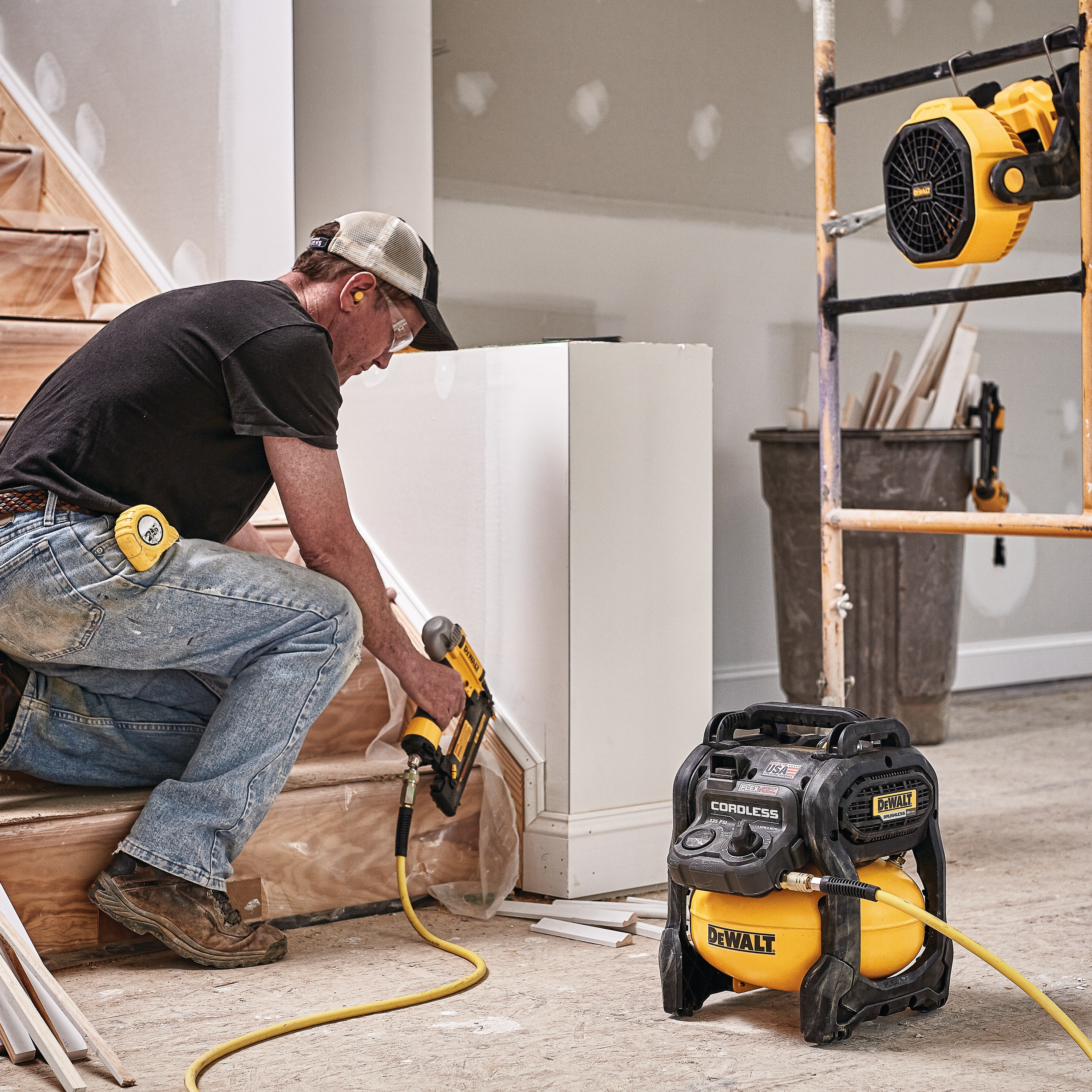 FLEXVOLT® 2.5 GALLON CORDLESS AIR COMPRESSOR being used by a person to power a pneumatic nailer for countersinking holes in a wood scotting