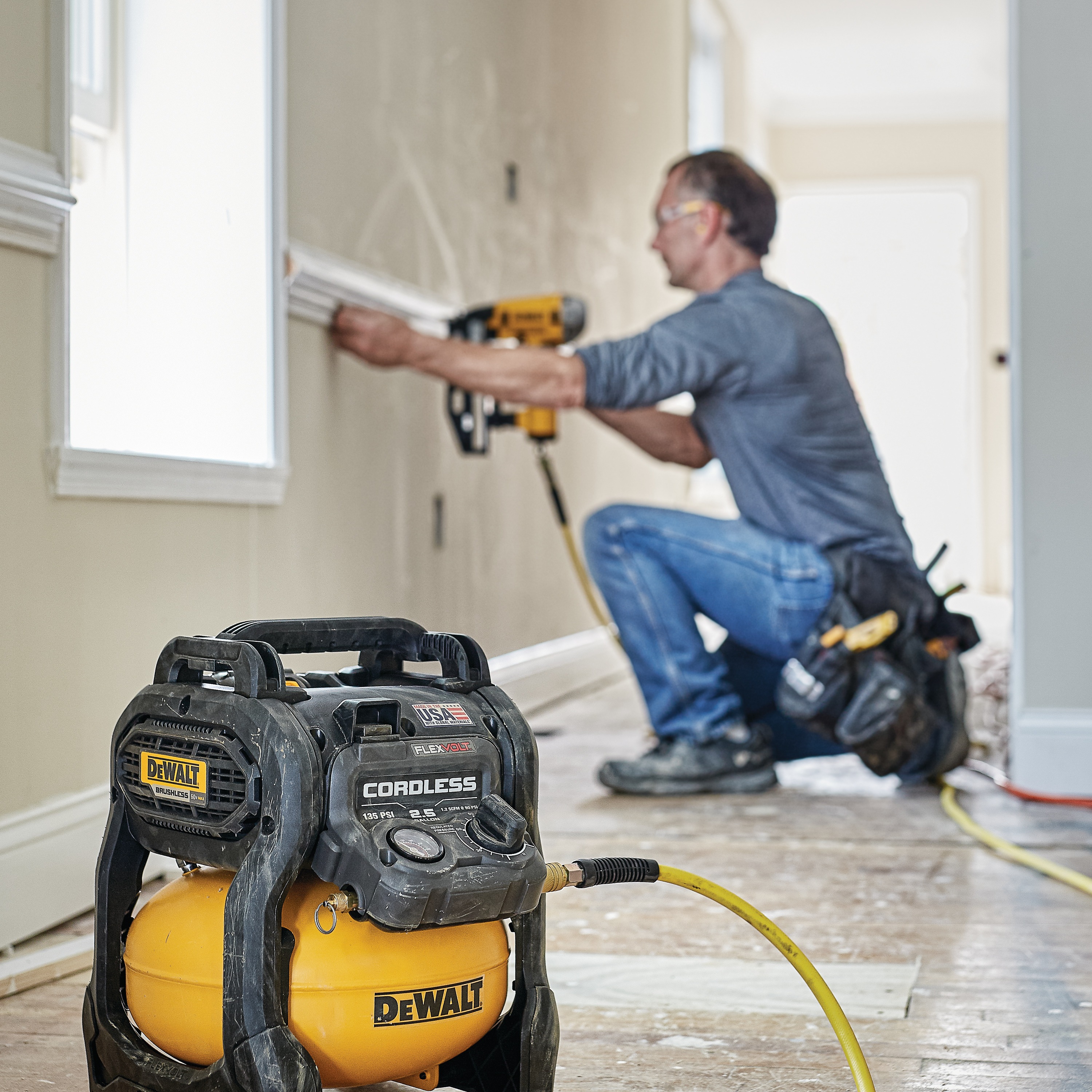 FLEXVOLT® 2.5 GALLON CORDLESS AIR COMPRESSOR being used by a person to power a pneumatic nailer