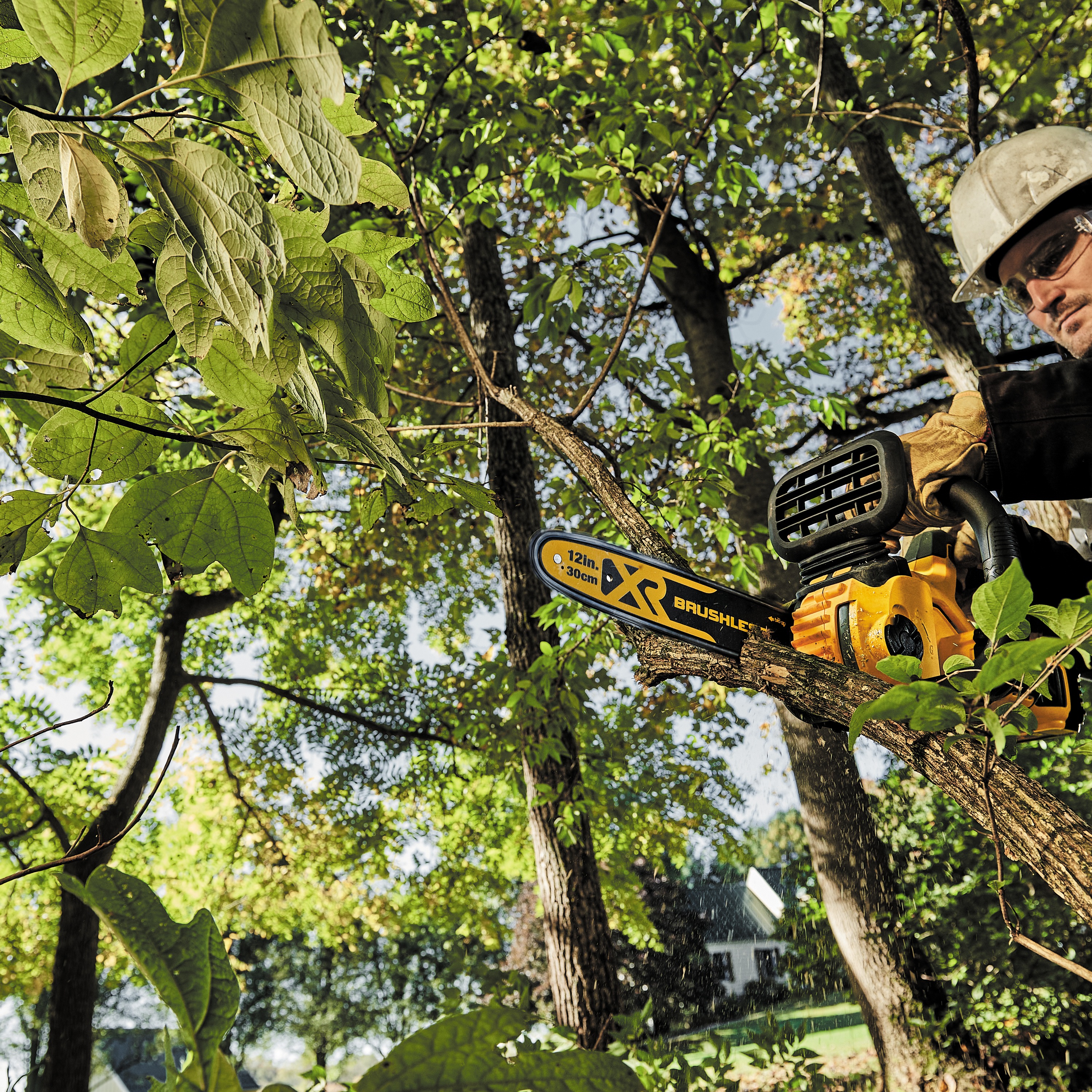 XR® Compact 12 inch Cordless Chainsaw being used by a worker to cut wood blocks out of a square log of wood at a construction site