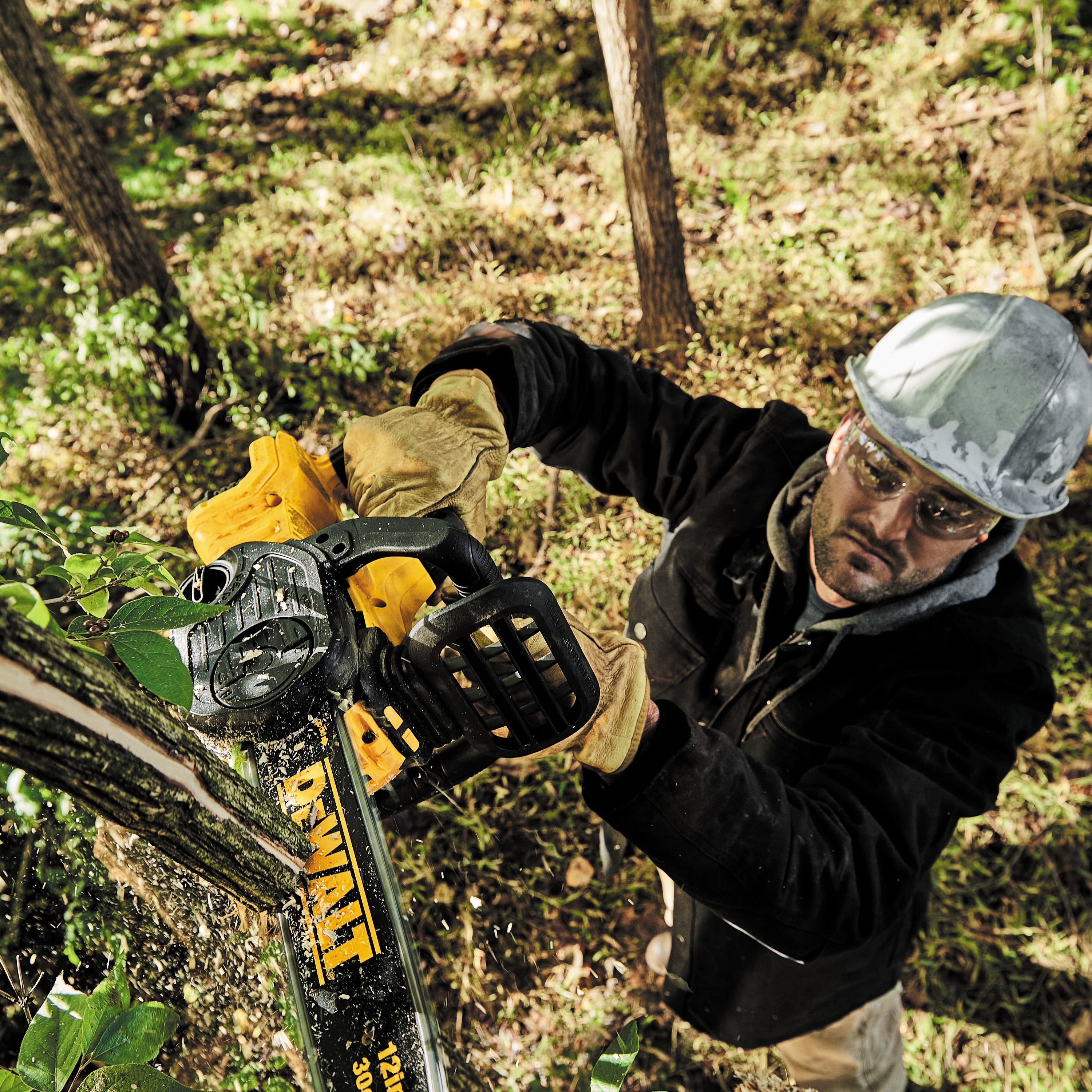 XR® Compact 12 inch Cordless Chainsaw being used by a person to slice through a square wooden log outdoors