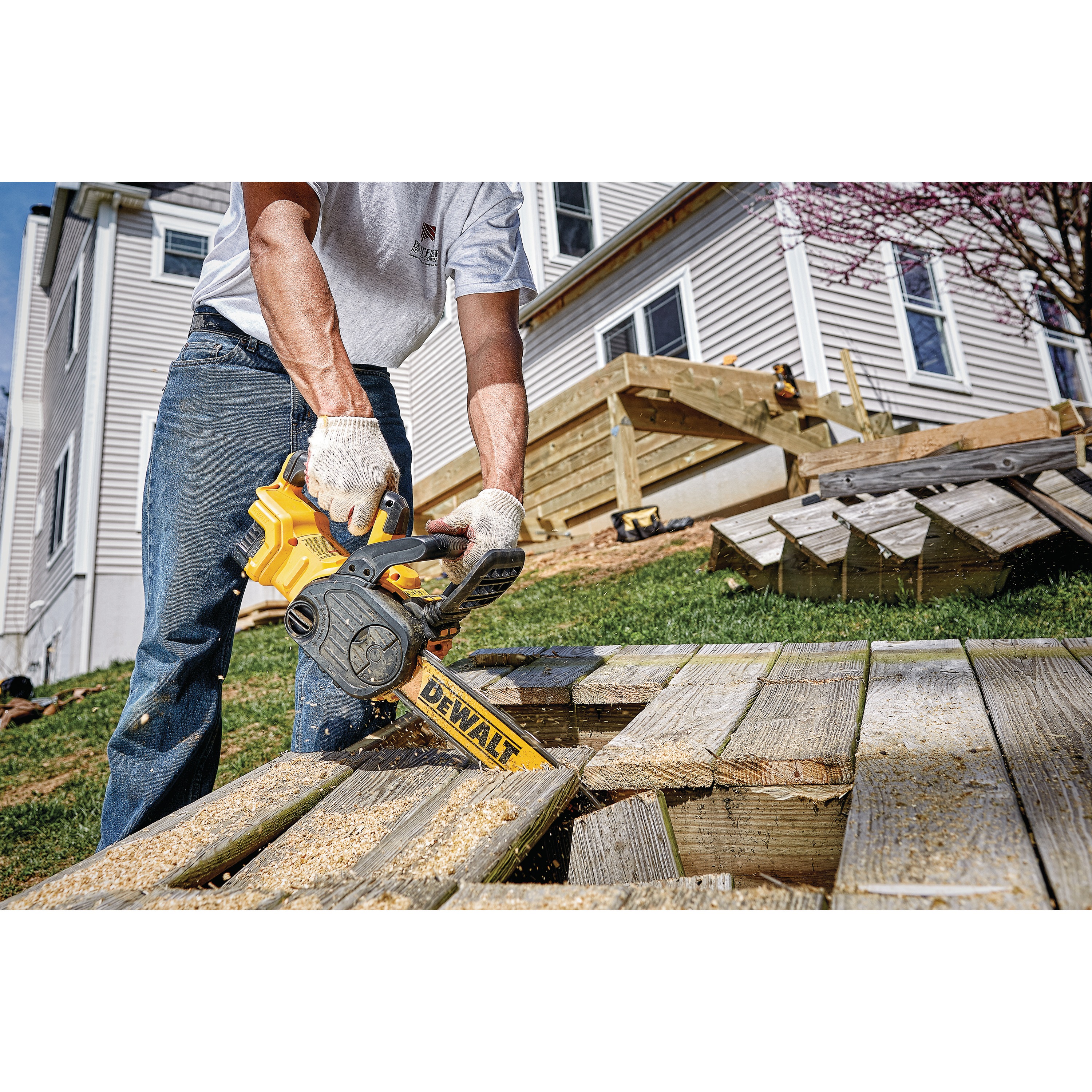 XR® Compact 12 inch Cordless Chainsaw being used by a person to cut through wooden planks outdoors