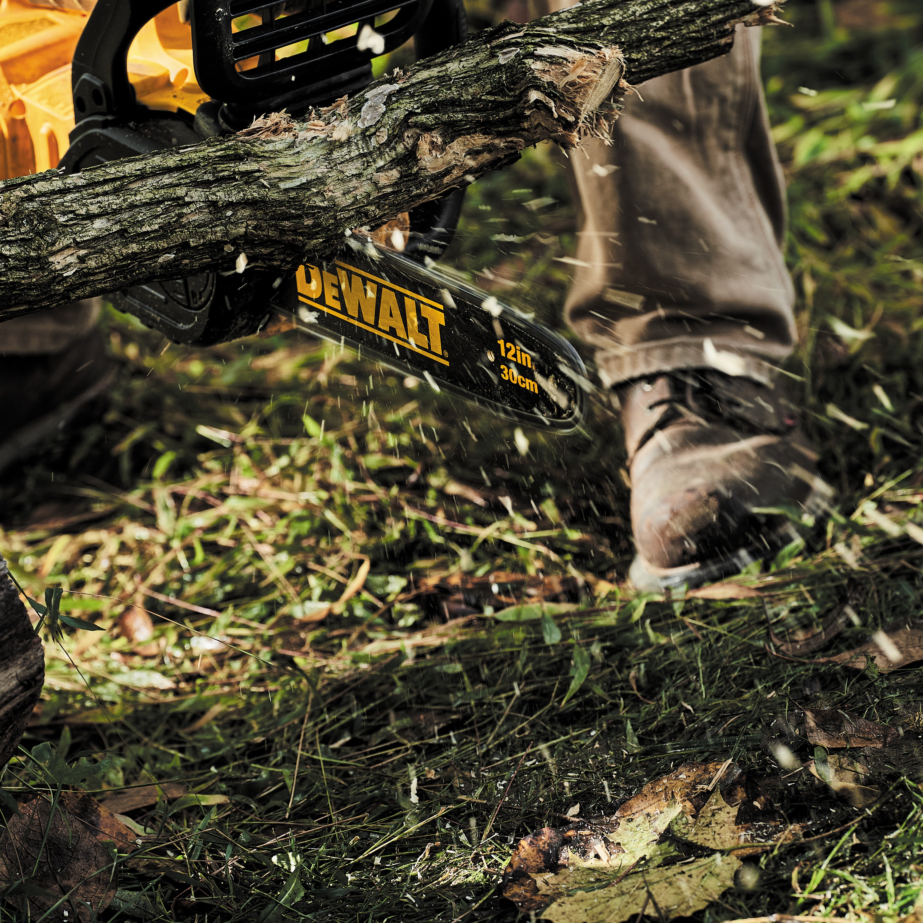 FLEXVOLT Cordless Chainsaw being used by a worker to cut large, thick tree trunks outdoors