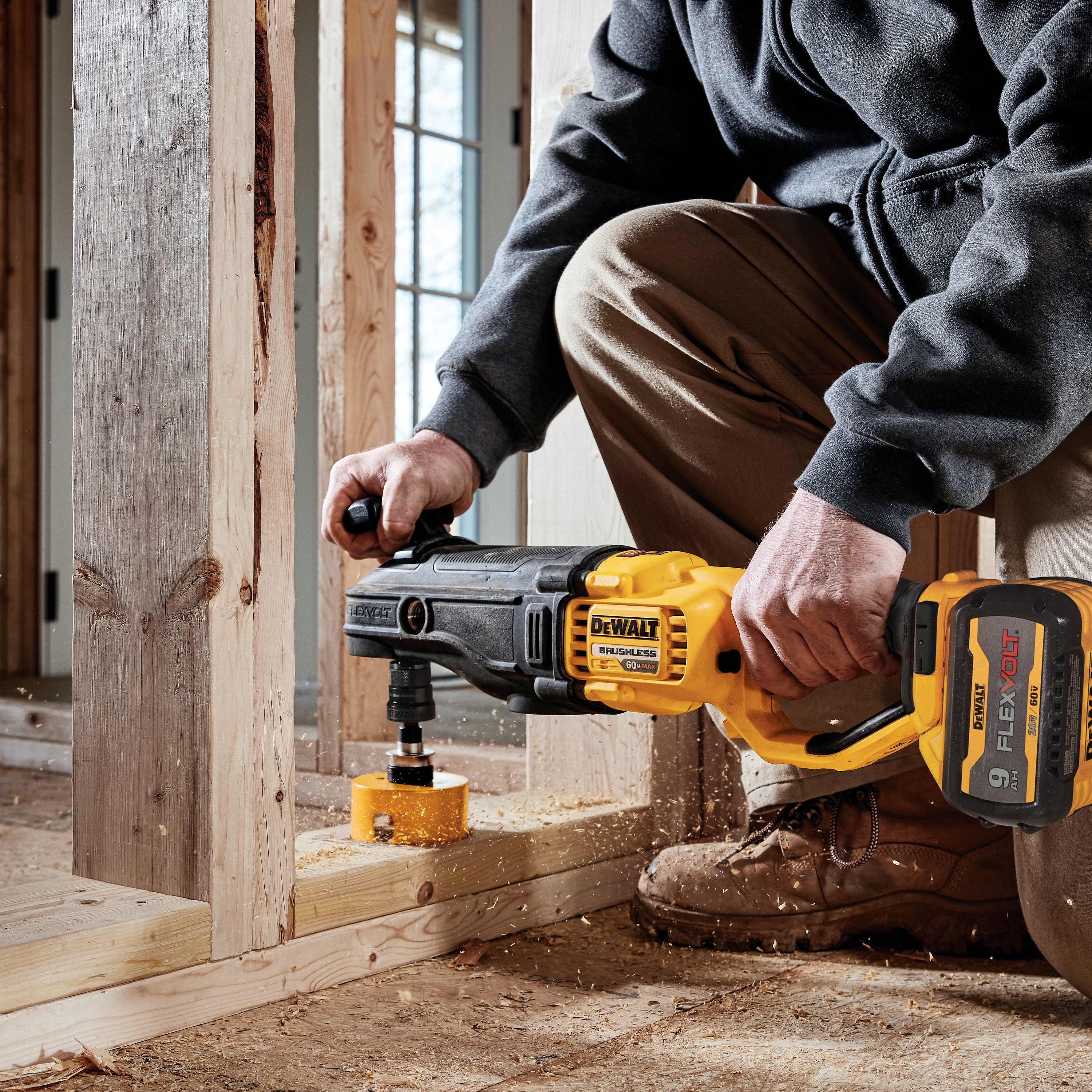 Brushless cordless quick-change stud and joist drill pressed against  wood.