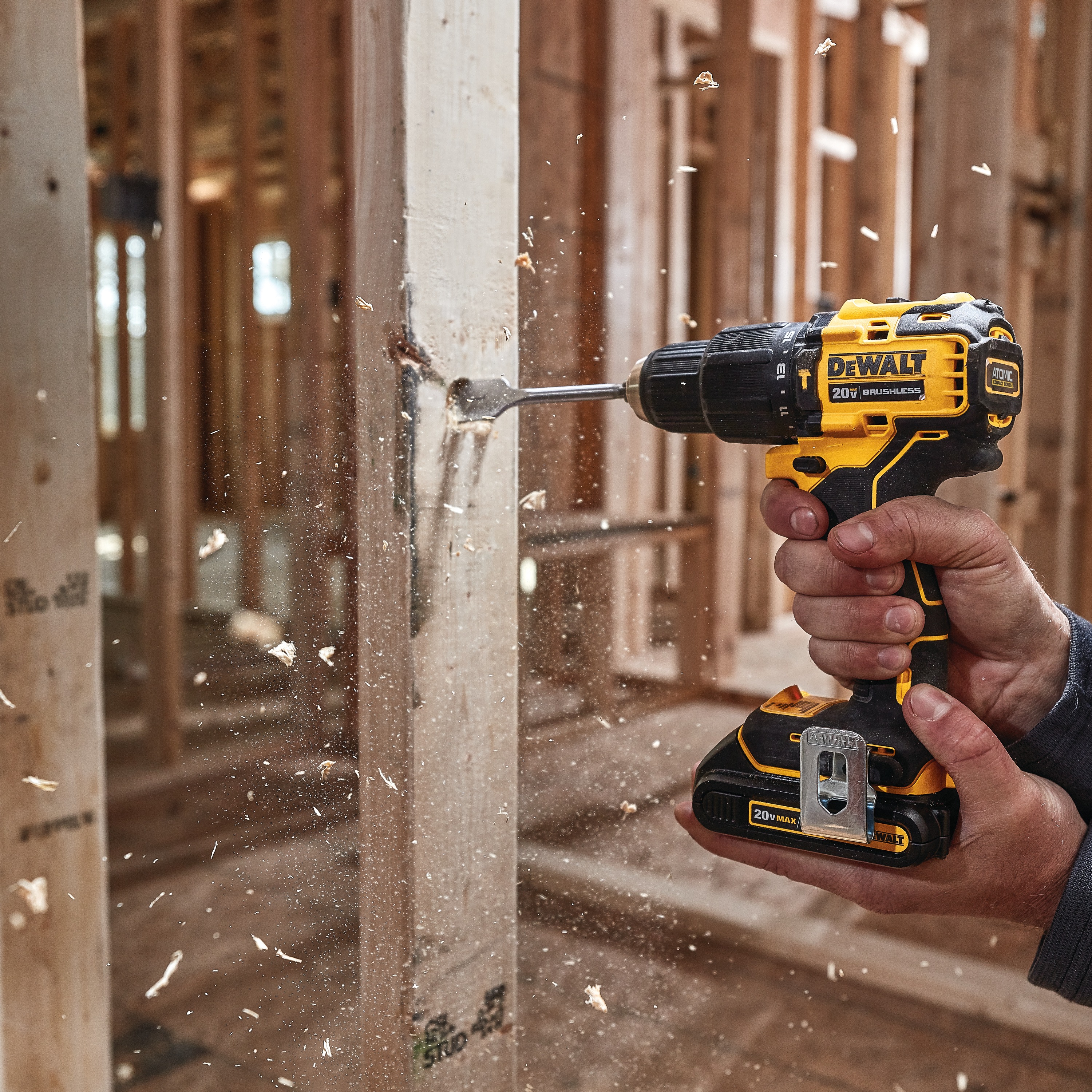 Atomic cordless compact half inch hammer drill driver drilling  wooden plank.