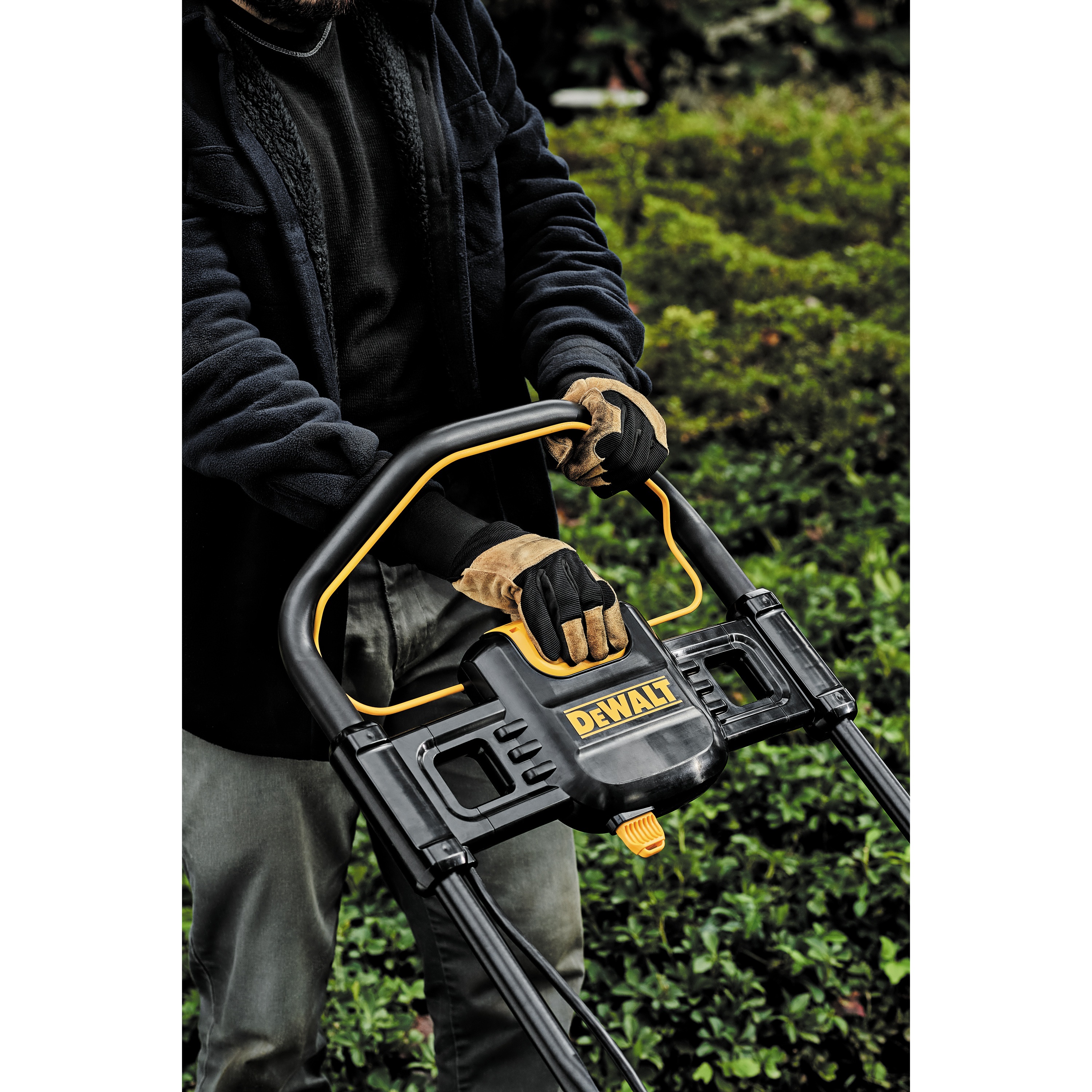 brushless cordless push mower being adjusted by a person