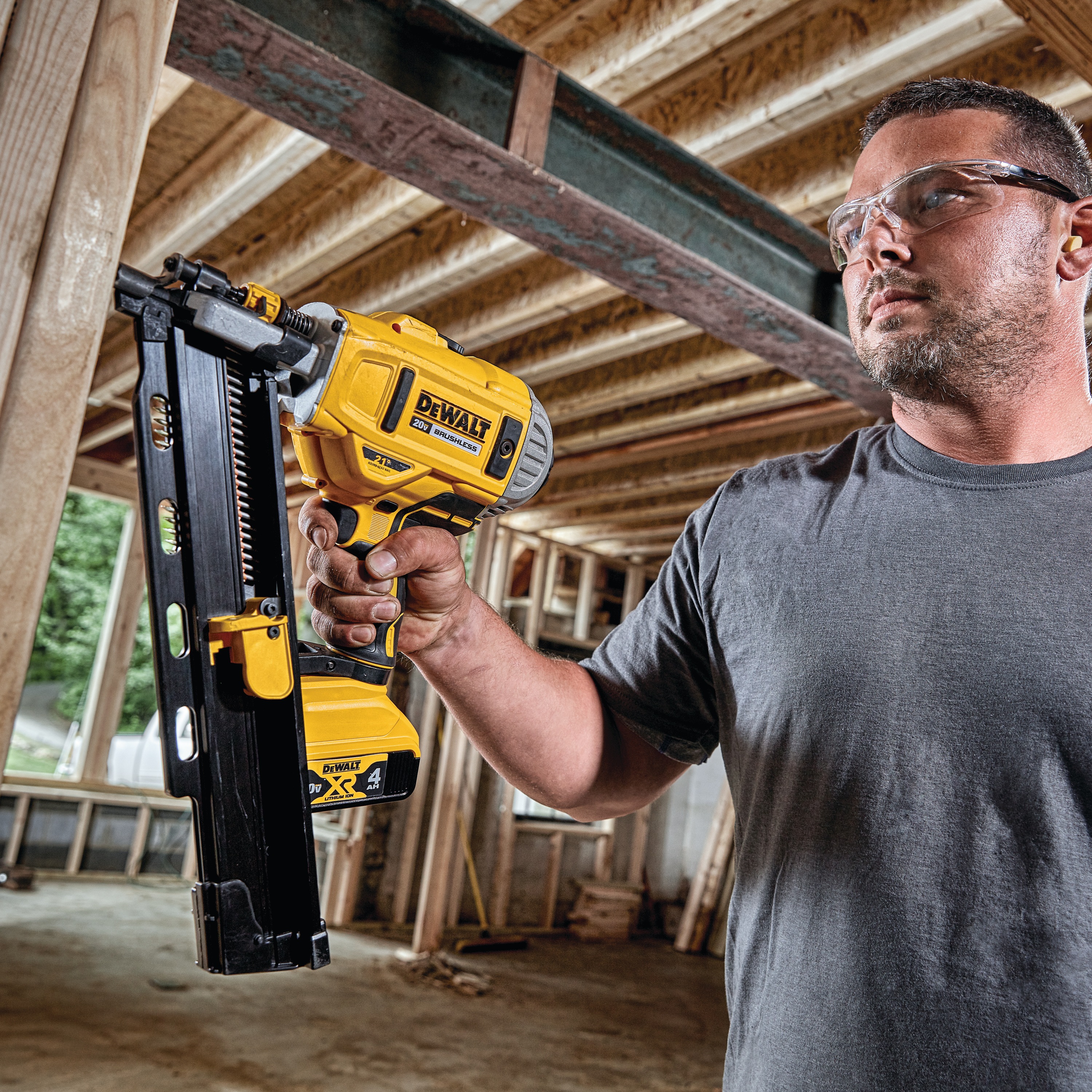 21 inch Plastic Collated Cordless Nailer in action by a man on a wooden frame at a construction site