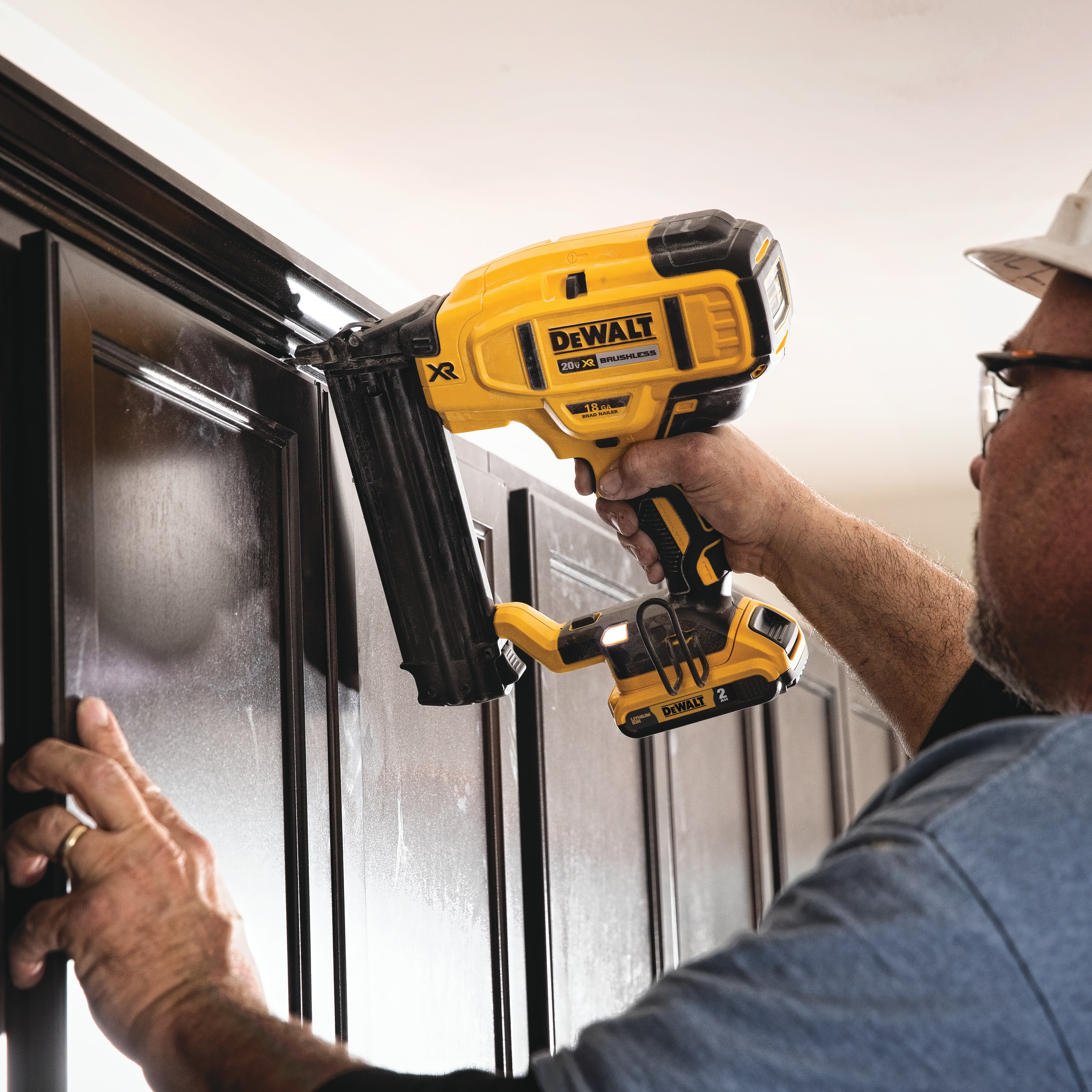 XR 18 gauge Cordless Brad Nailer in action on wooden panel by a construction worker
