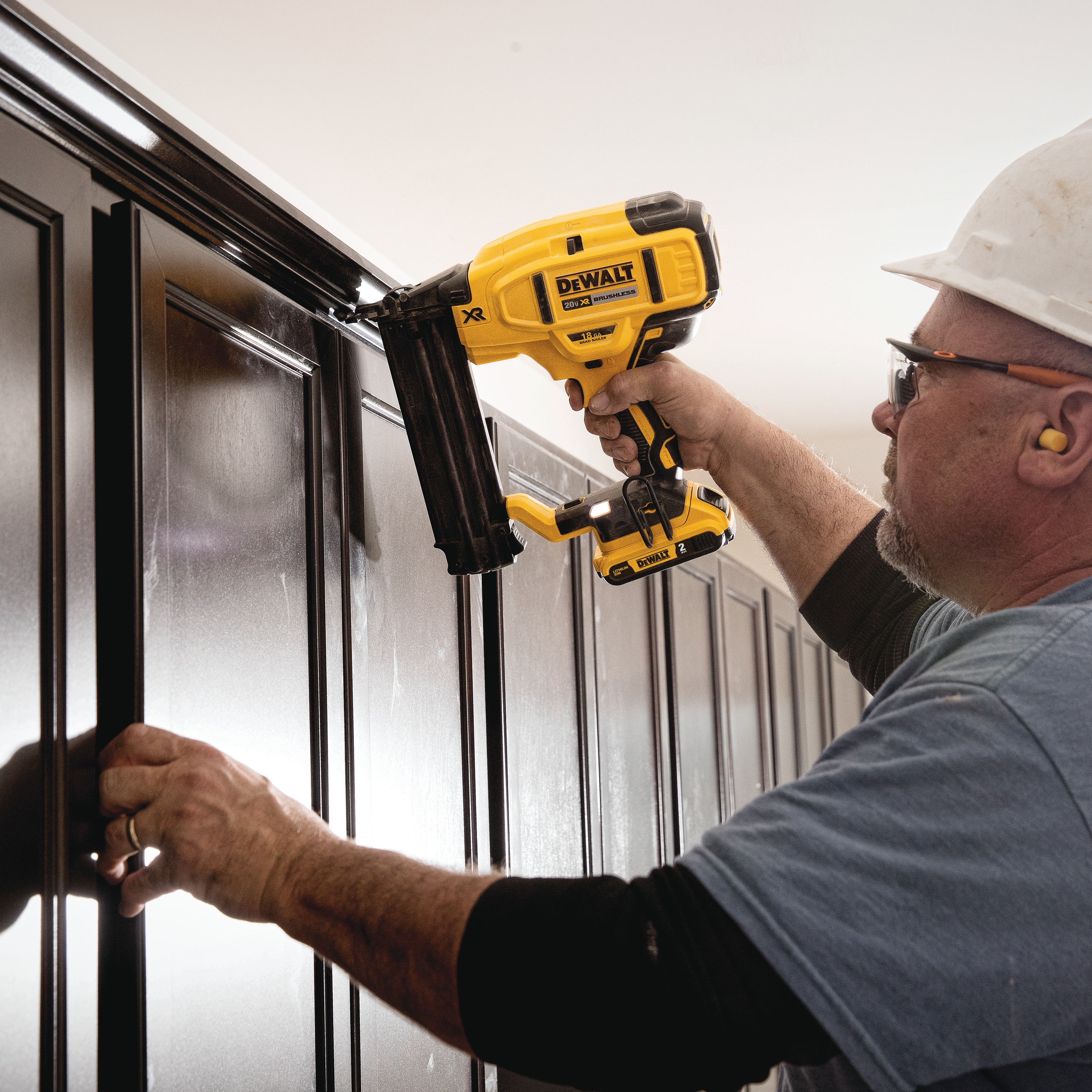 XR 18 gauge Cordless Brad Nailer in action on a wooden wall by a construction worker