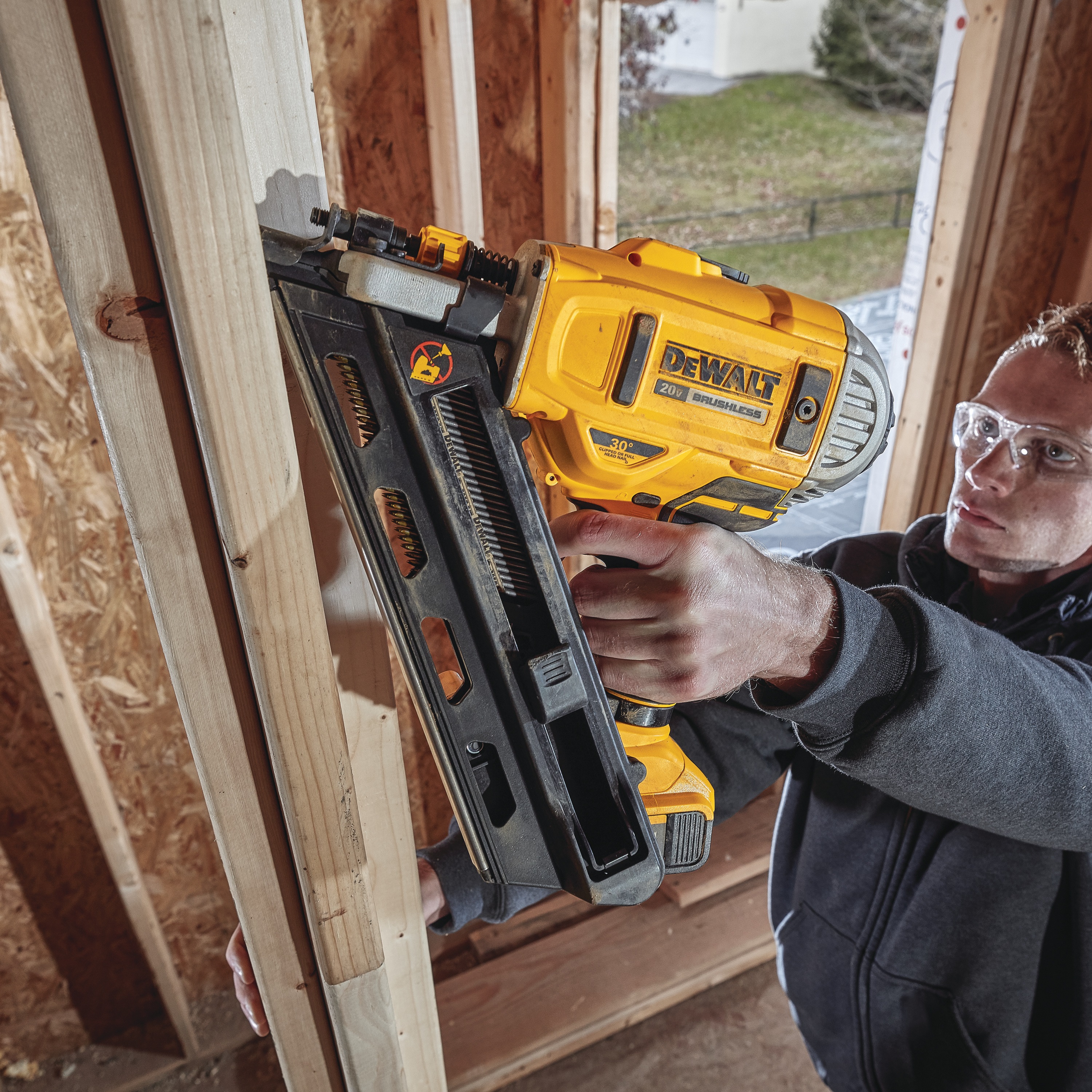 Cordless Paper Collated Framing Nailer in action on a wooden pillar by a construction worker at a construction site