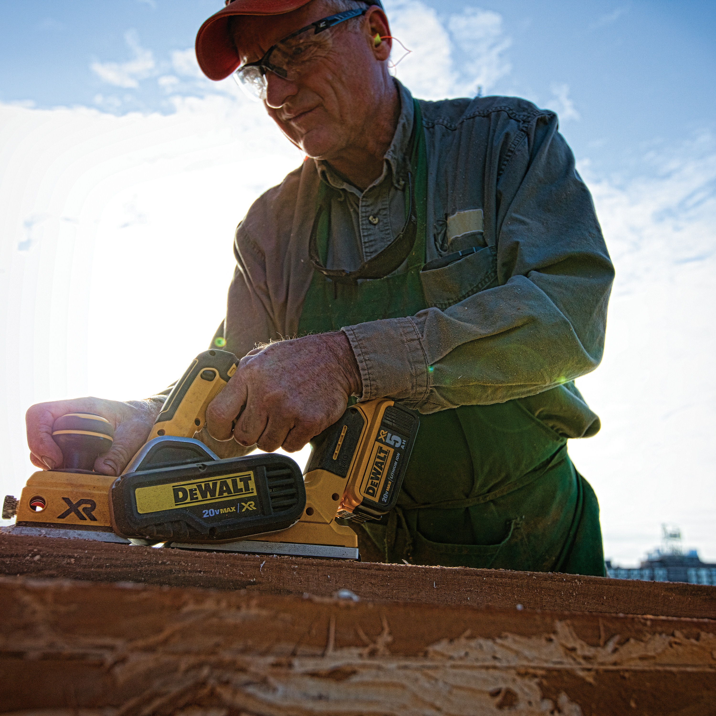 Brushless cordless planer being used by a person to ensure parallelism of cut.