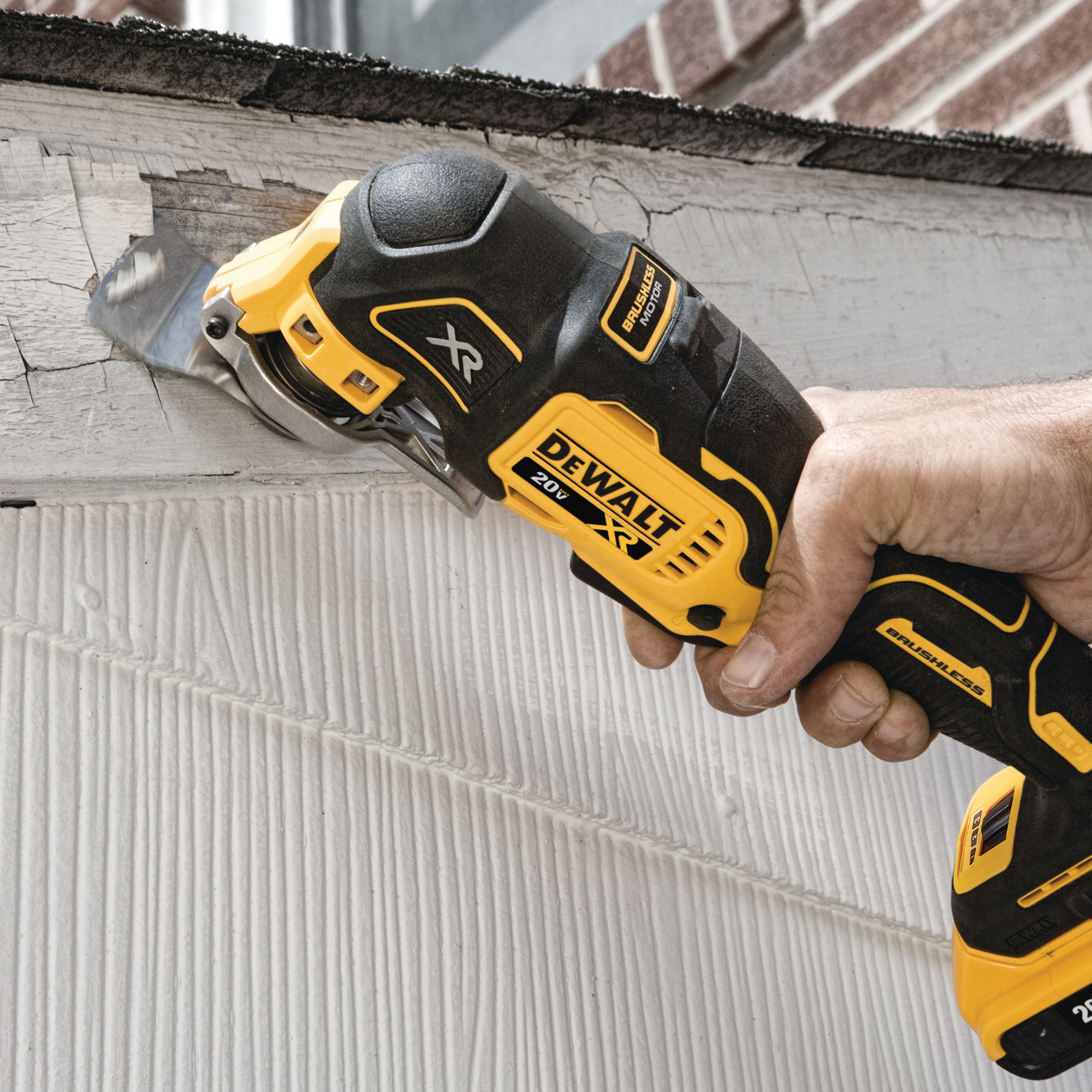 XR Cordless Oscillating Multi Tool being used by person to remove blistered paint from a wall