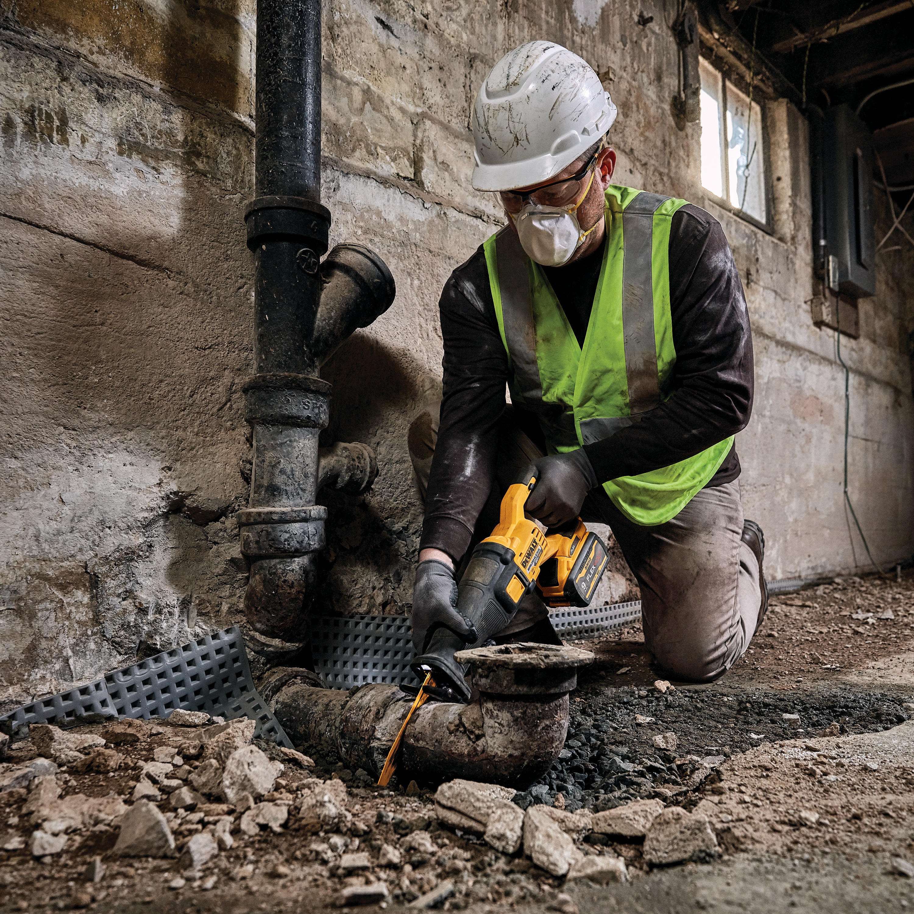 FLEXVOLT brushless cordless reciprocating saw being used by person on drainage pipe.