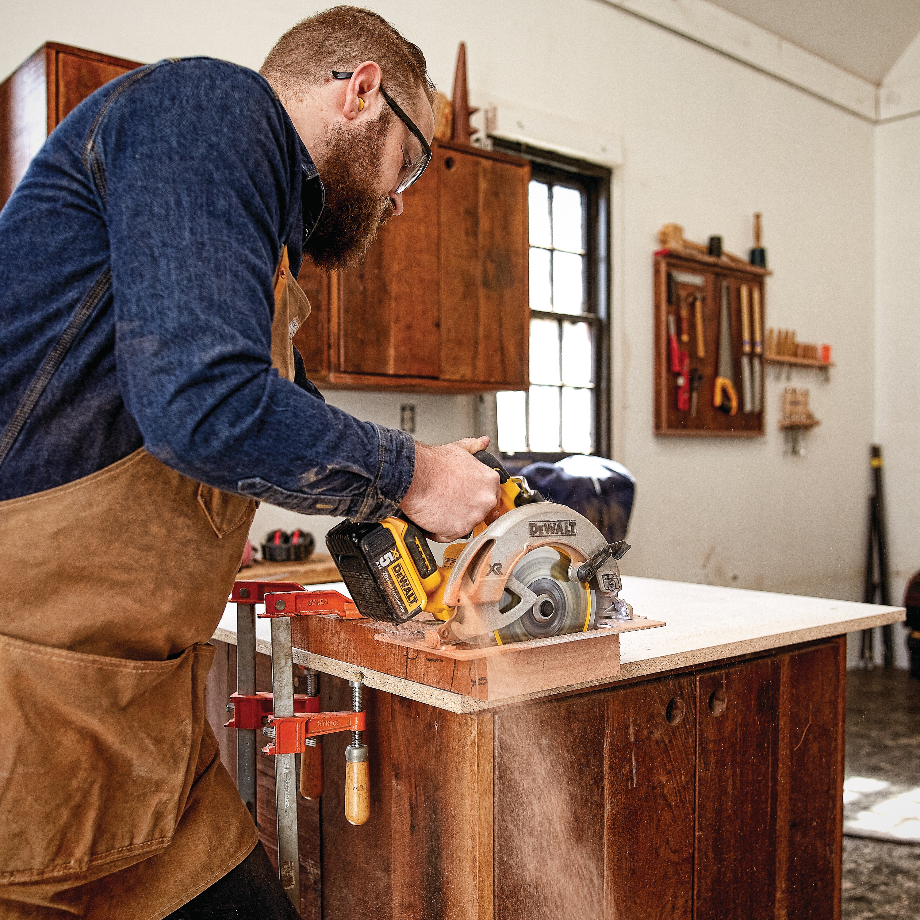 Profile of Cordless circular saw being used by person on wood.