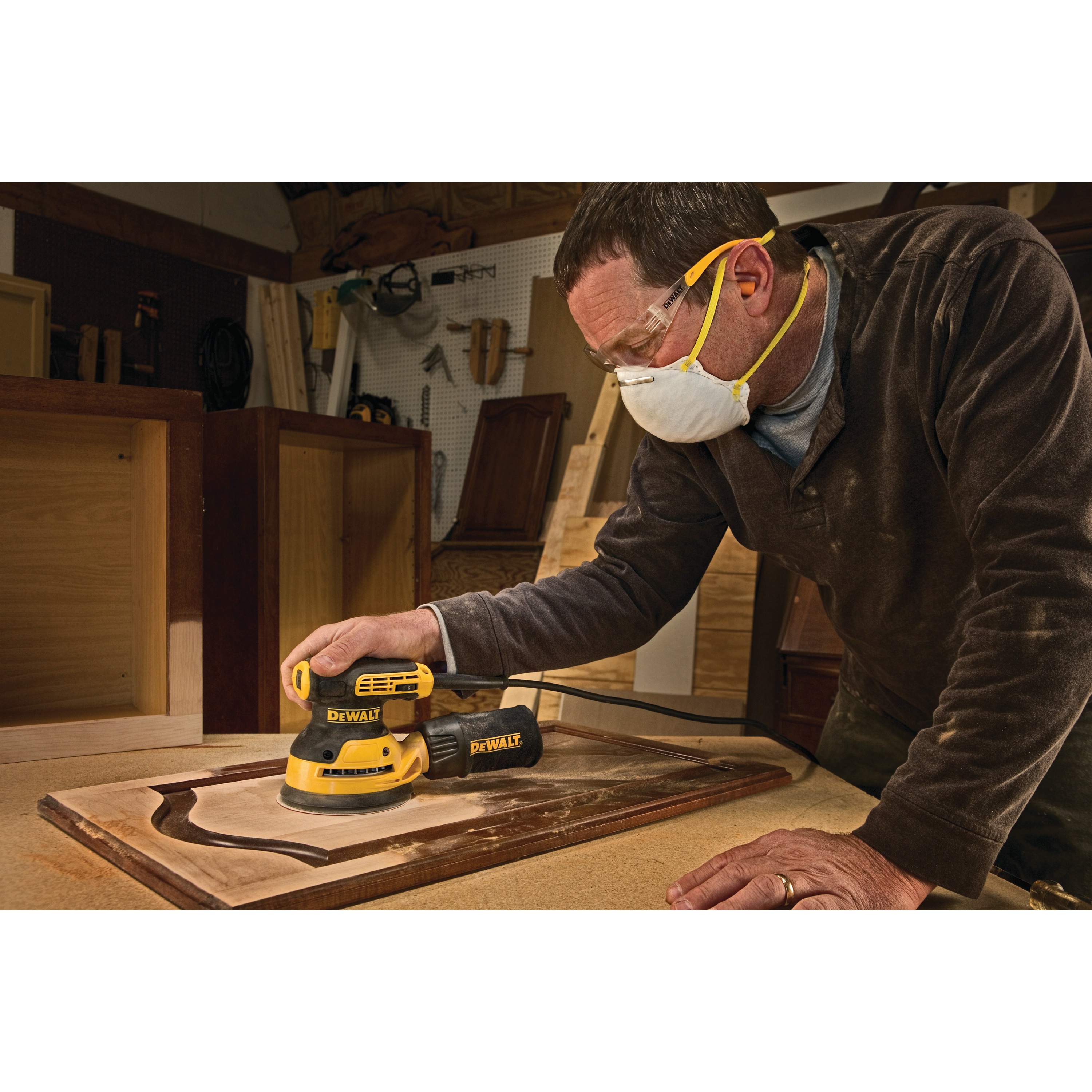 5 inch variable speed random orbit sander with H and L pad being used to sand a wooden panel by a worker at a worksite.