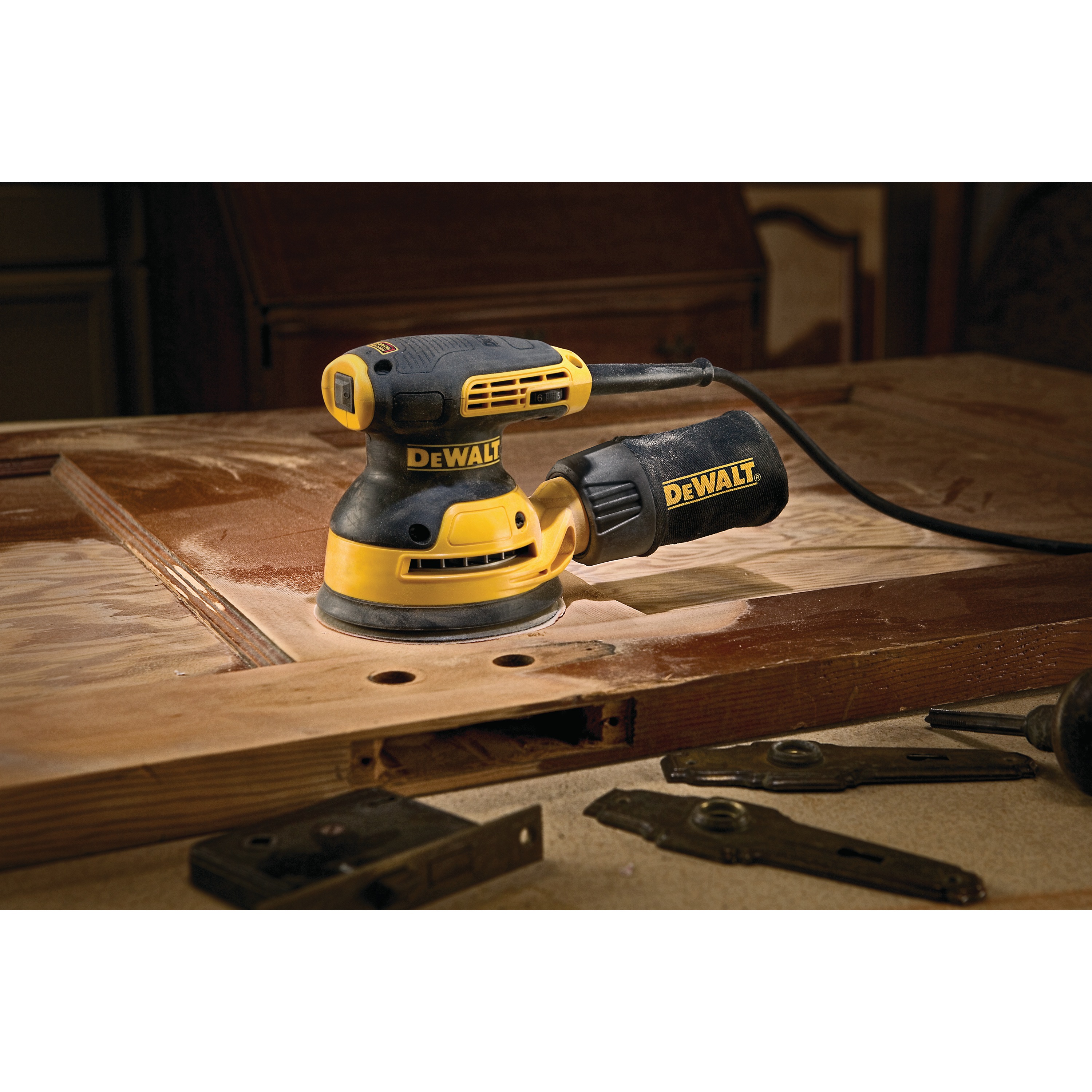 5 inch variable speed random orbit sander with H and L pad placed on top of a wooden sheet.