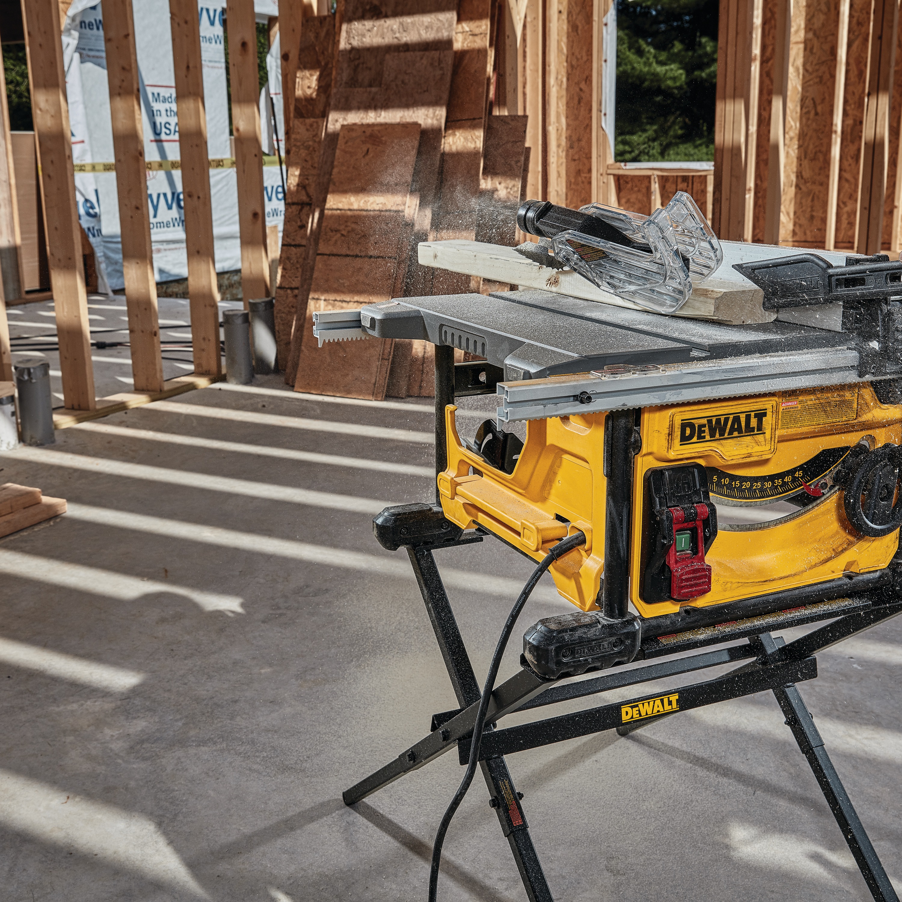 Compact Jobsite table saw cutting through wooden plank.