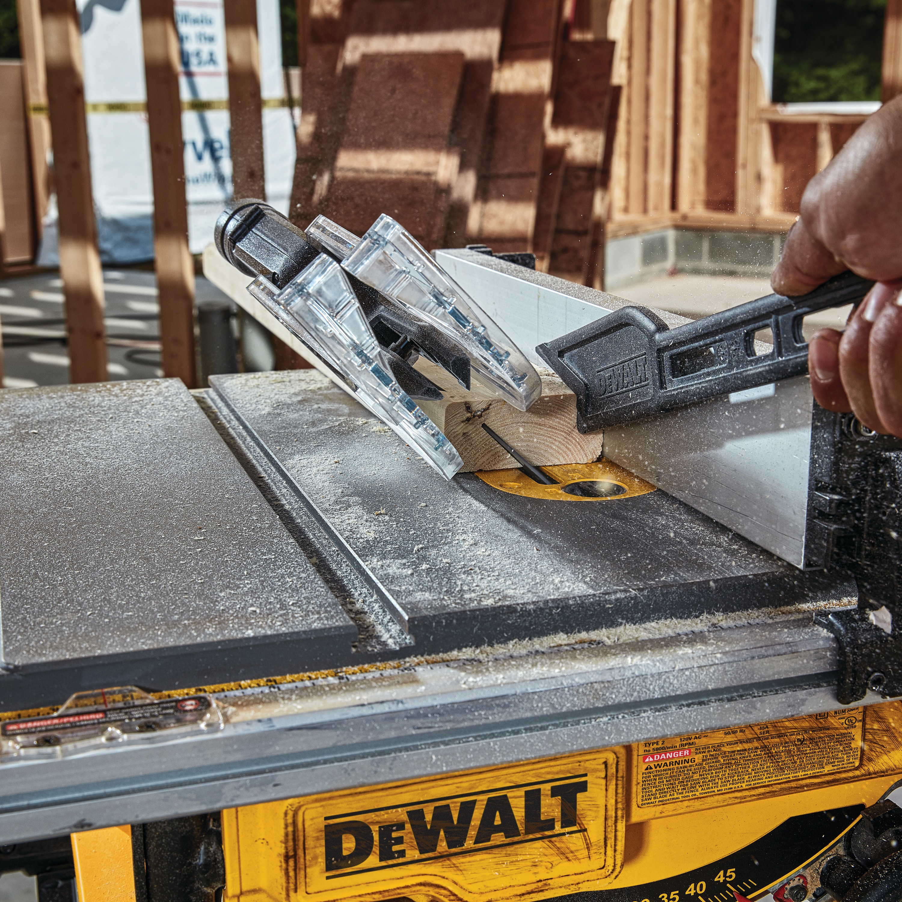Close up of Compact Jobsite table saw cutting through wooden plank.