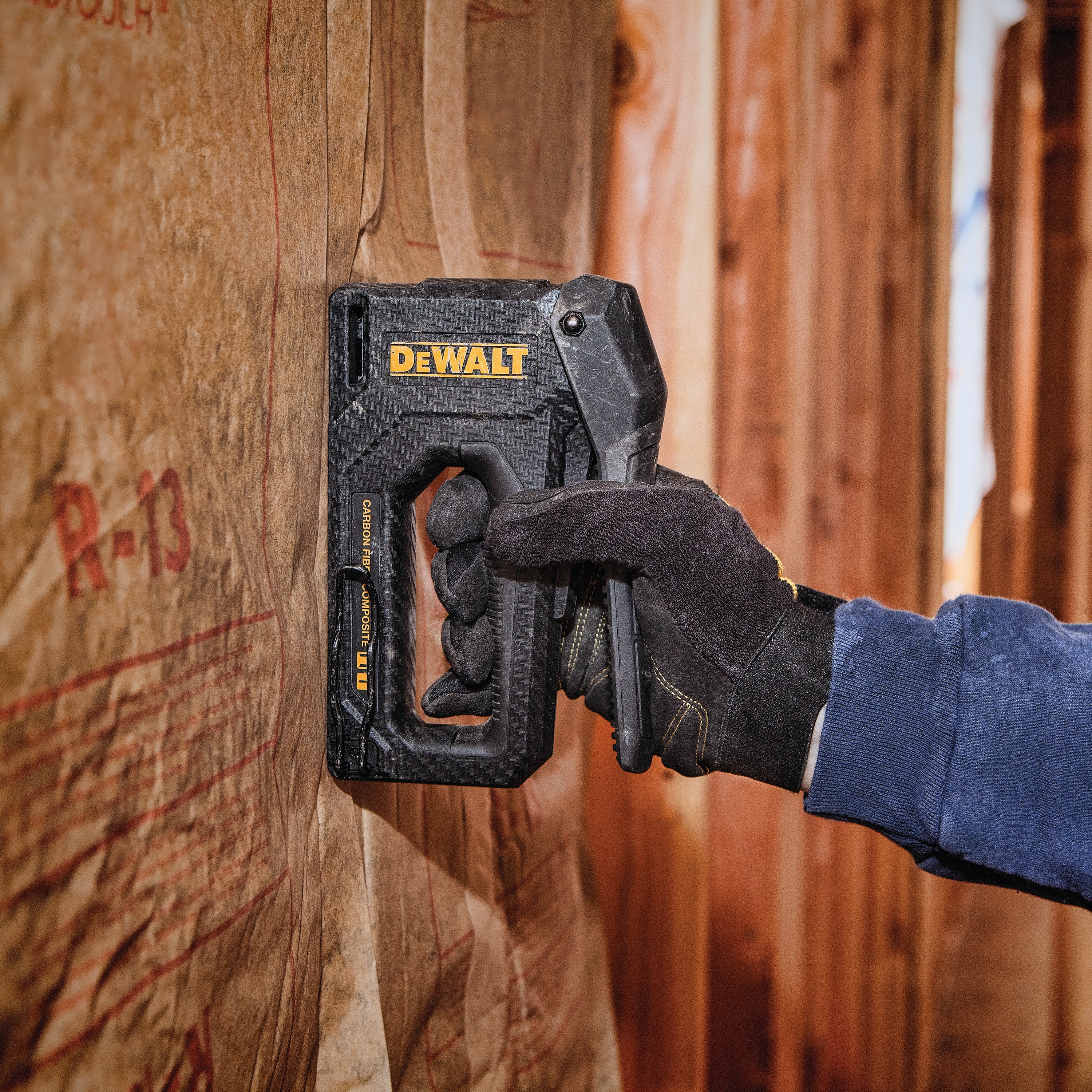Carbon Fiber Composite Staple Gun being used to staple underlay on  wall.