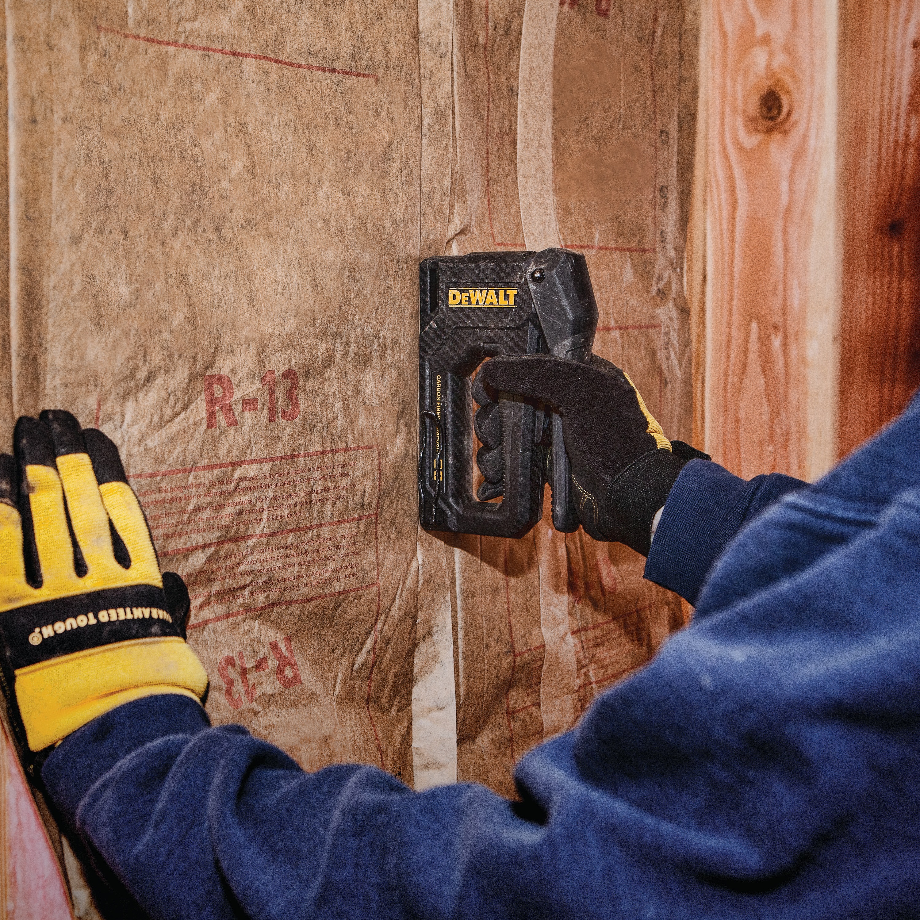 Carbon Fiber Composite Staple Gun being used to staple underlay on  wall.