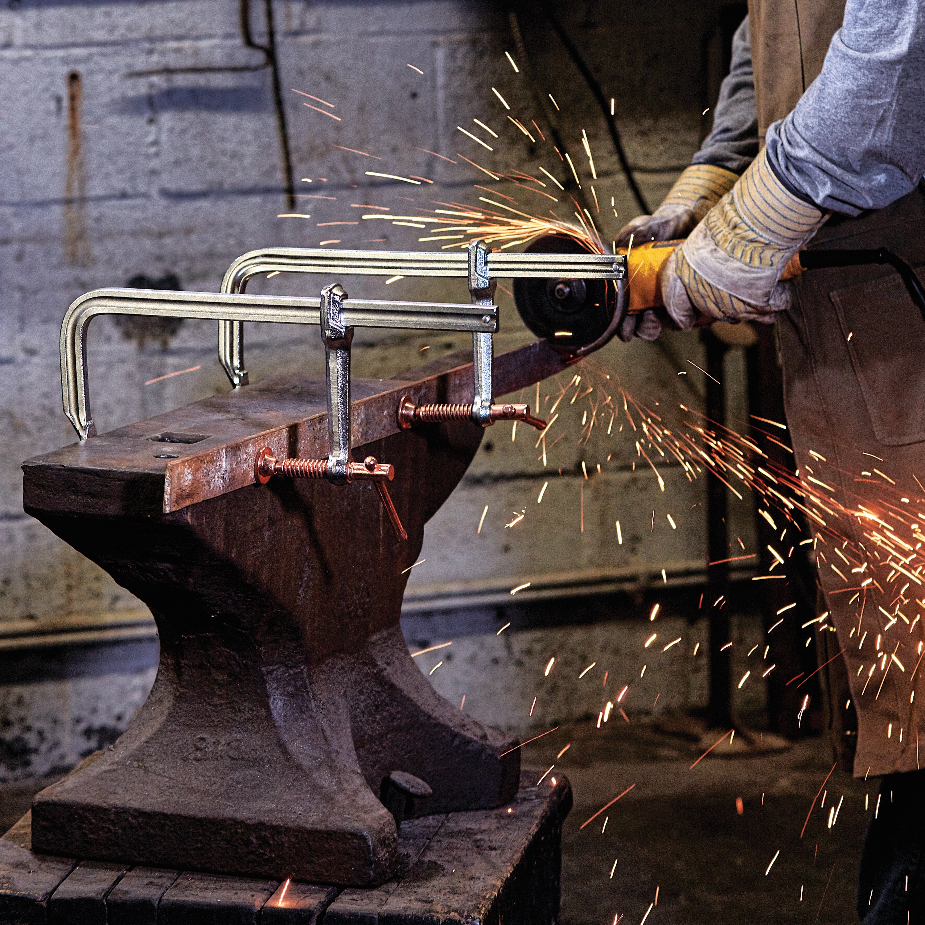 12 inch Metalworking bar Clamp being used by a person in a workshop.