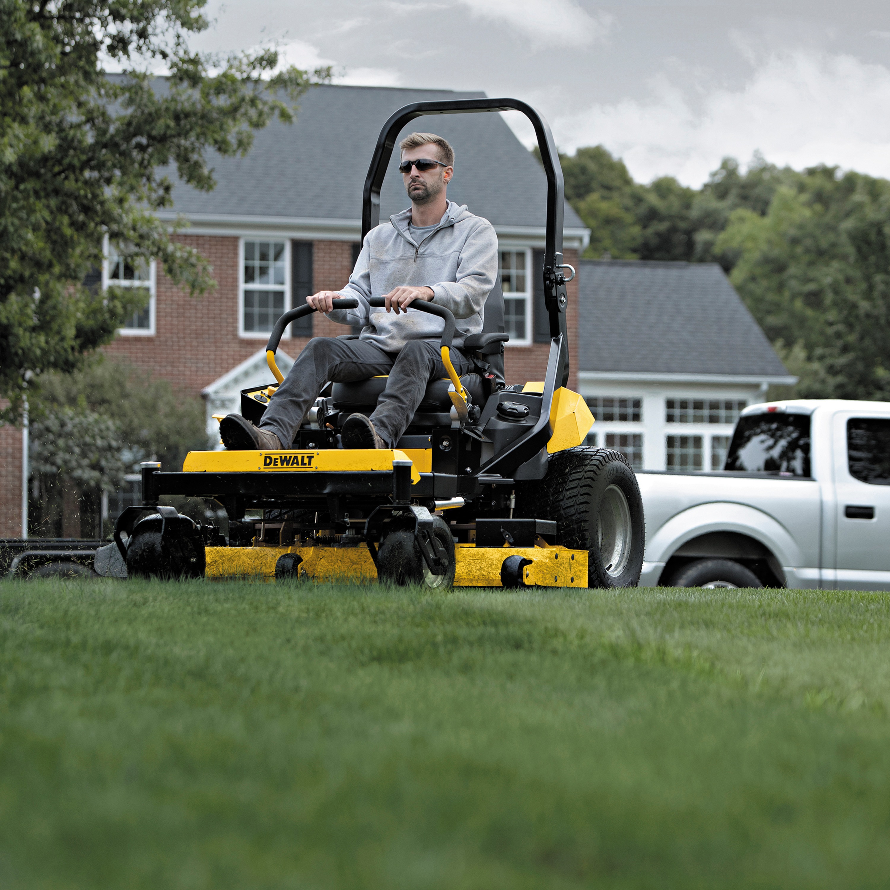 54 inch Kawasaki Gas Hydrostatic Commercial Zero Turn Mower being used by person to mow lawn outdoors. 
