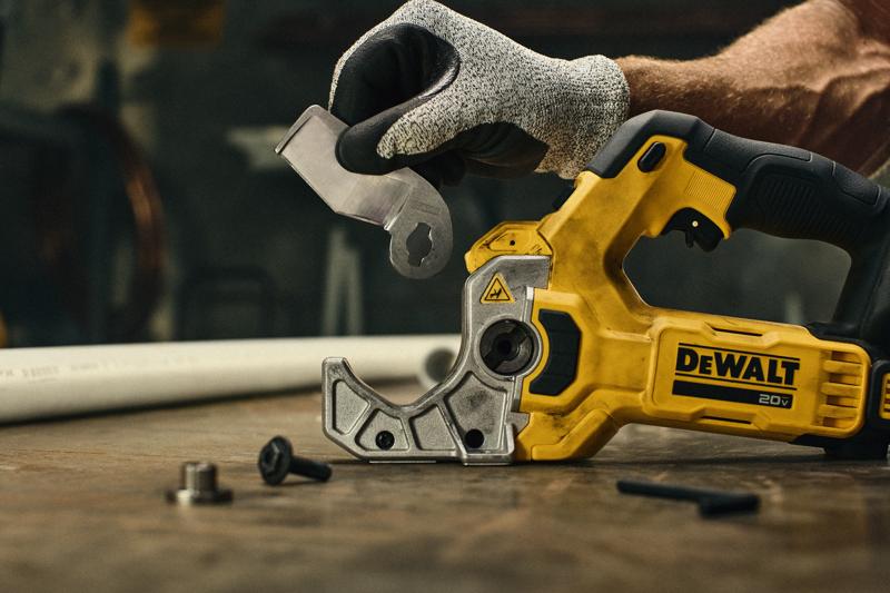 DEWALT Plastic Tubing Cutter on a table top with user changing the blade.