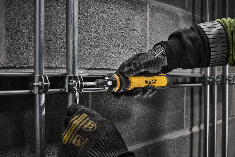 Worker tightening electrical conduit clamps on a commercial jobsite with DEWALT 4V USB Screwdriver