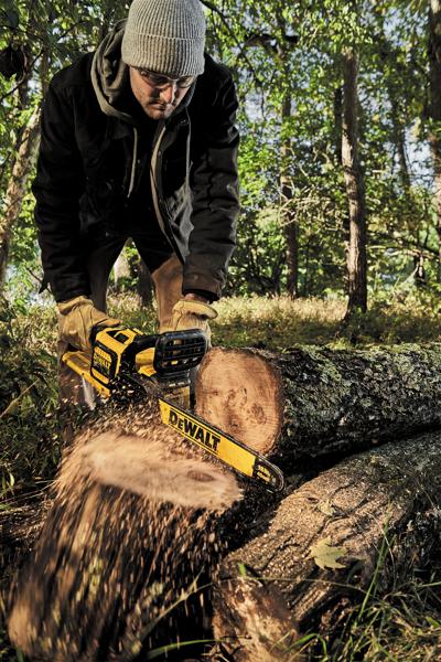 Brushless chainsaw being used to cut a tree by a person.