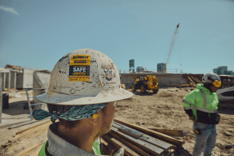 Concrete worker with Safety hard hat stickker on jobsite