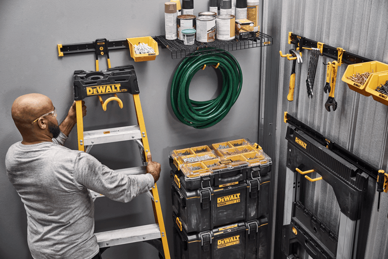 A Person Grabbing a Ladder off of a DEWALT Metal Rail Featuring Lawn/Garden Kits