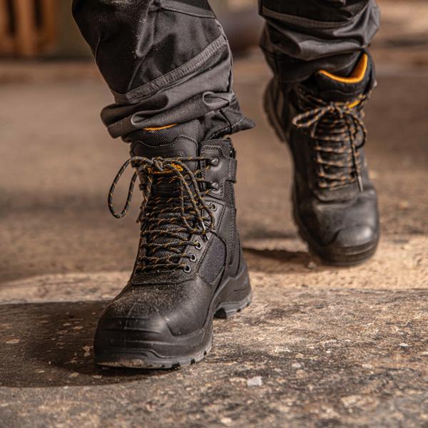 Front view facing left of the DEWALT Bryant men’s side zip safety boot in black on model on location