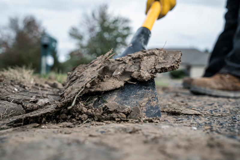 32 inch Fiberglass D-Handle Scraper close up scraping mud off pavement