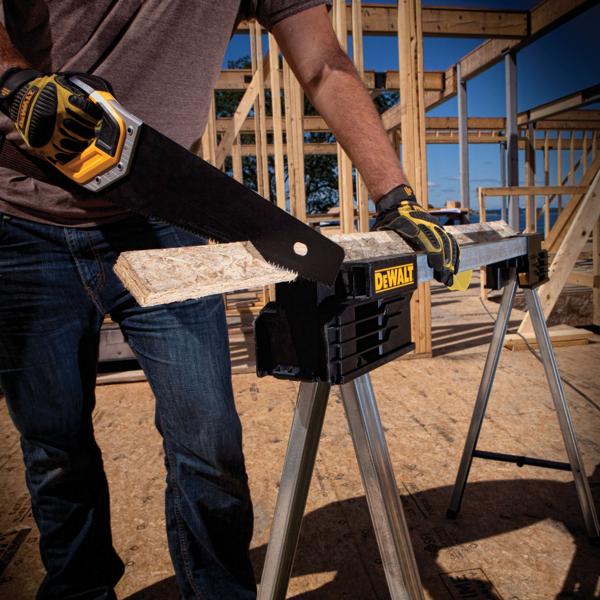 Metal folding sawhorse holding a wooden plank as it is being sawed through.