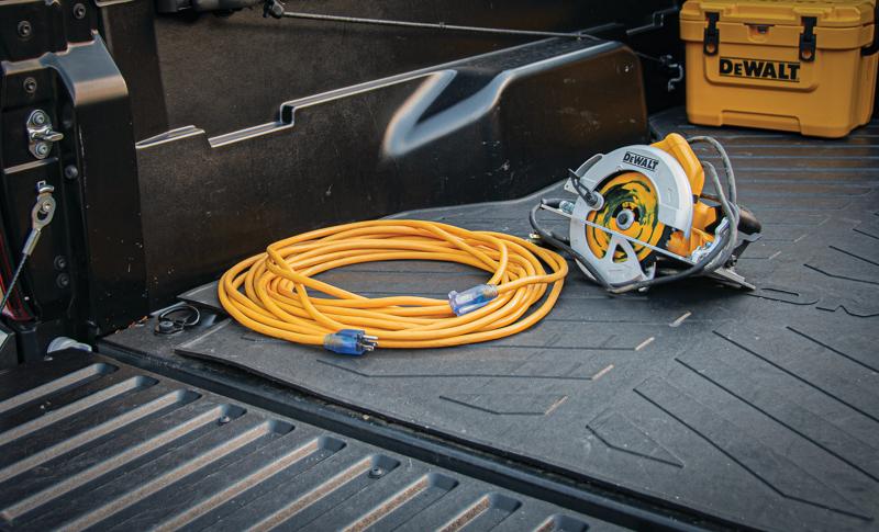 100 feet twelve thirds Lighted C G M Extension Cord at rest in cargo bed of truck with other tools.
