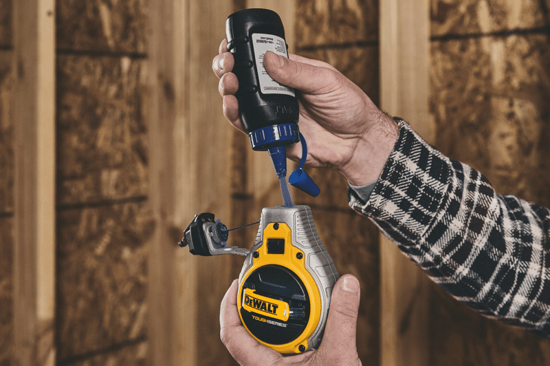 Putting blue chalk in the DEWALT TOUGHSERIES™ Chalk Reel