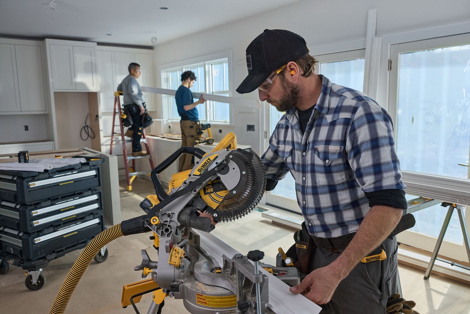 A carpenter uses a miter saw