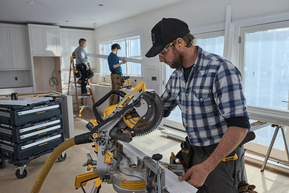 A carpenter uses a miter saw