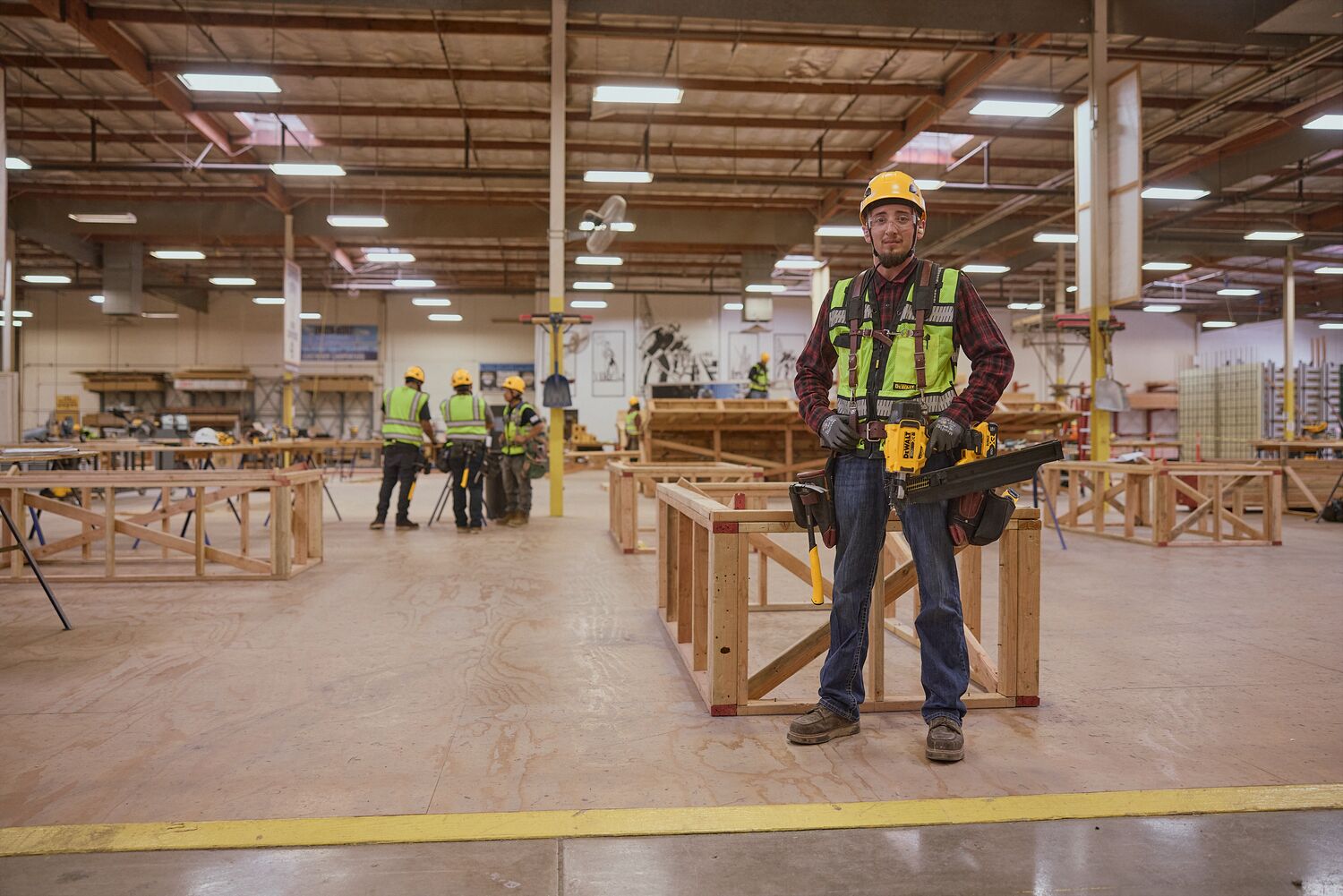 Apprentice wearing DEWALT safety gear in carpentry training center