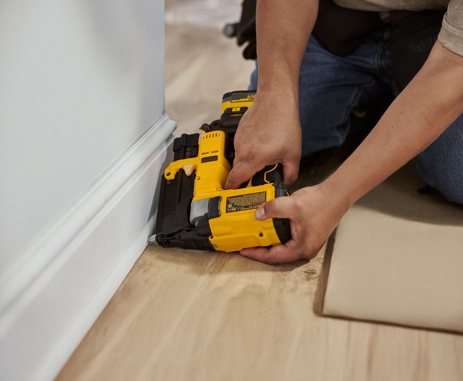 A carpenter uses a finish nailer