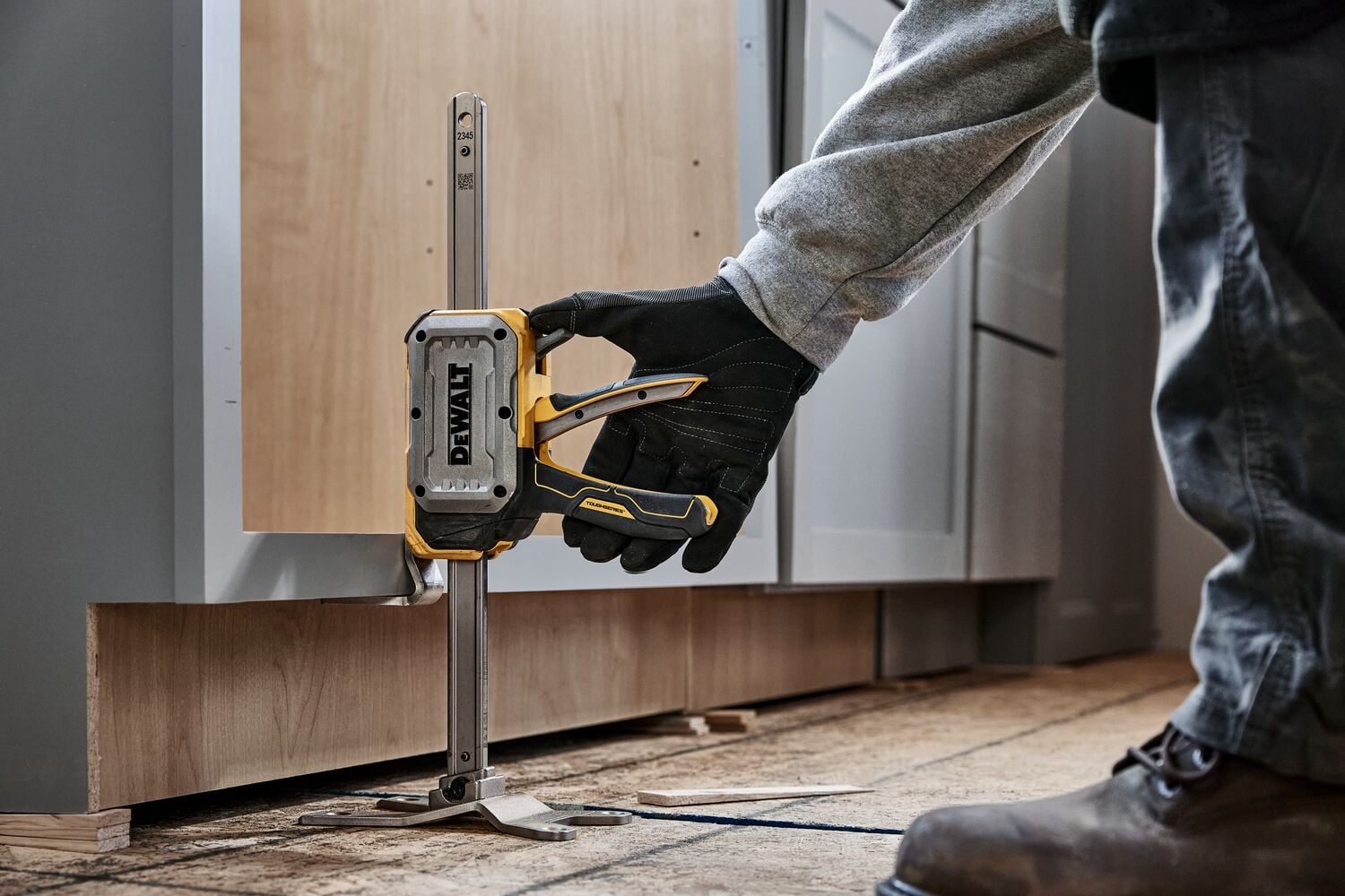 Worker leveling a cabinet with DEWALT(R) TOUGHSERIES(TM) CONSTRUCTION JACK