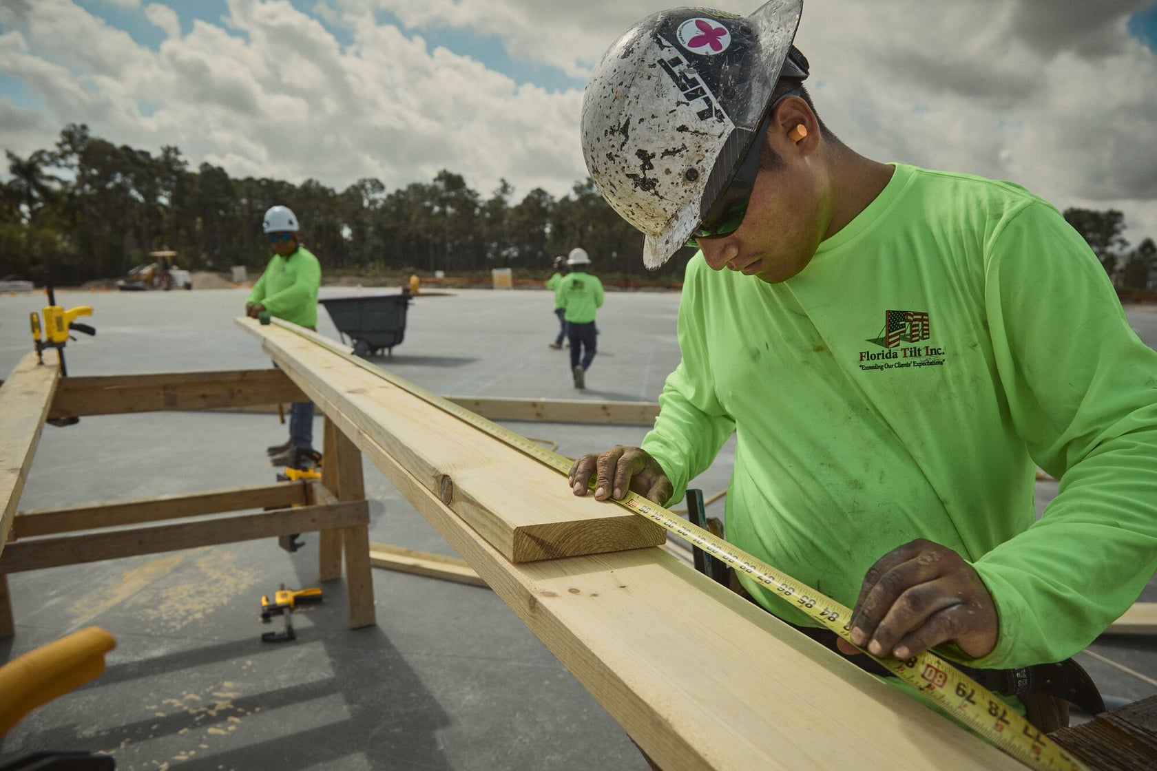 Concrete worker measuring wood beam