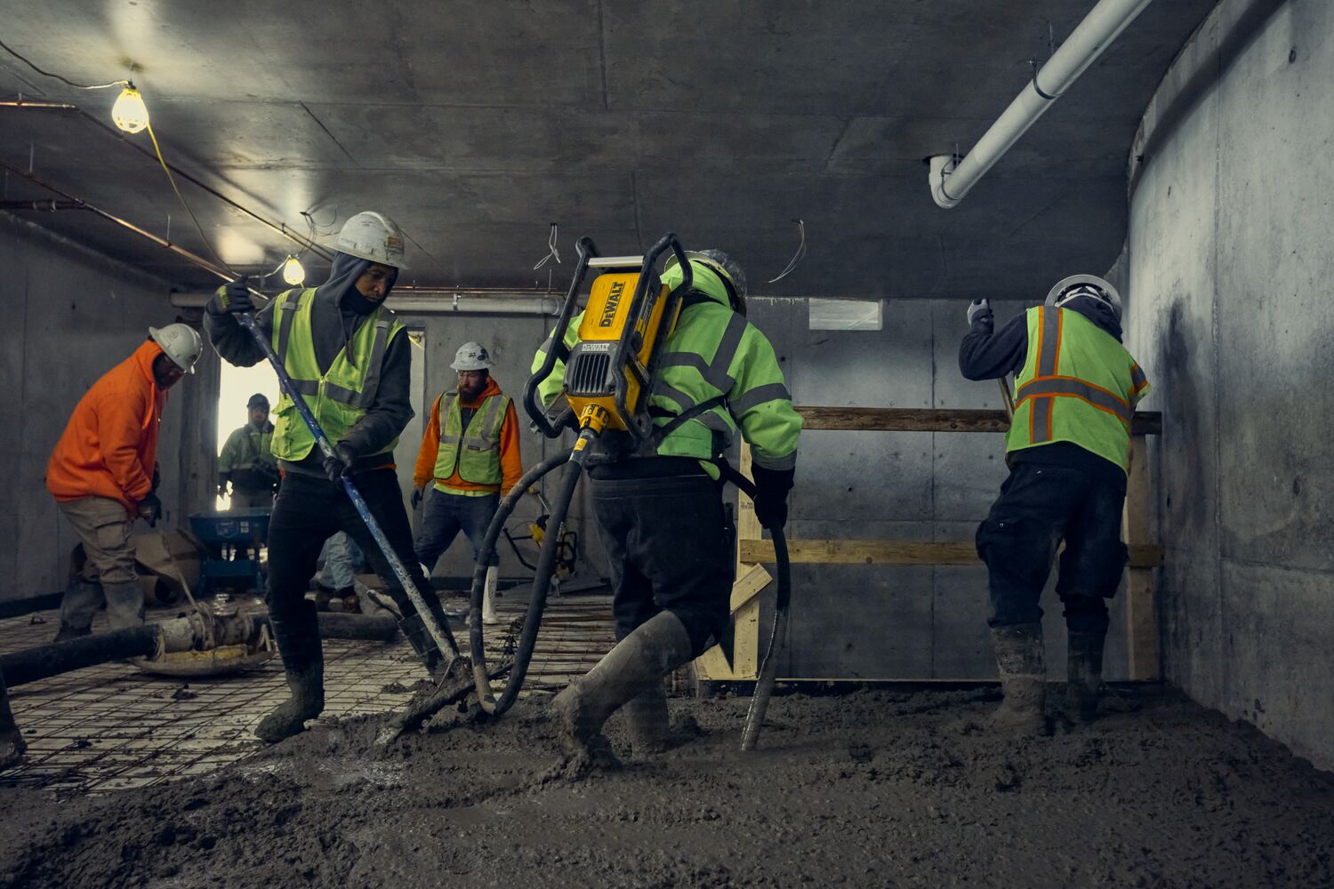 Concrete crew using DEWALT POWERSHIFT backpack vibrator in a small space