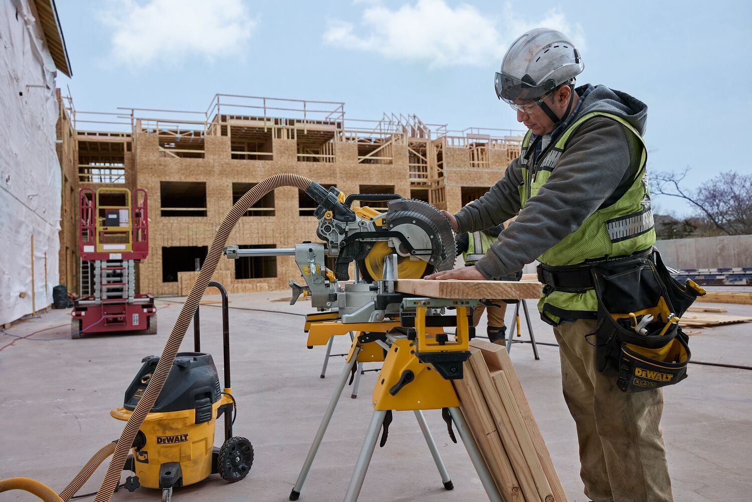 A carpenter uses a miter saw outside on the jobsite