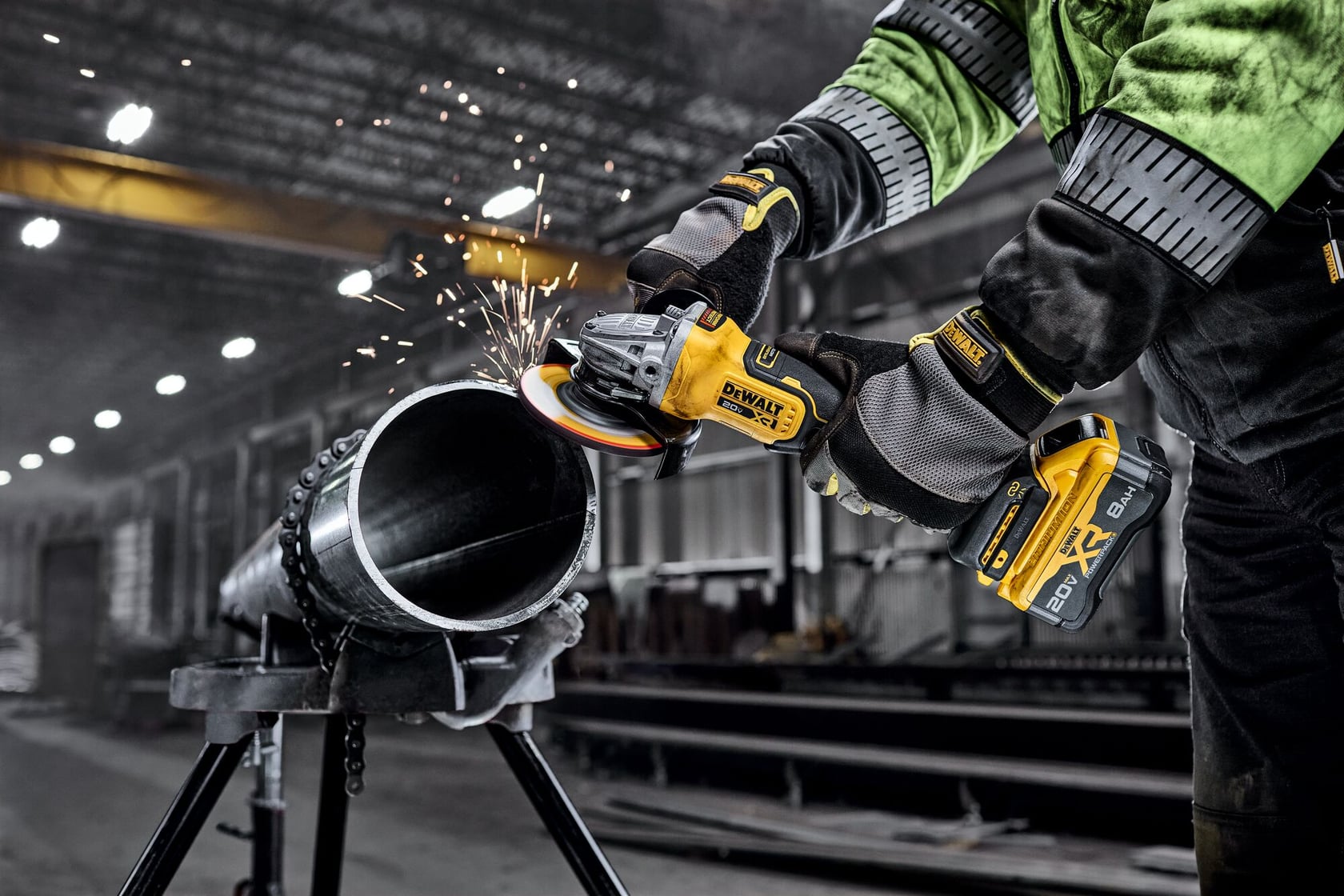 DEWALT 20V MAX* XR® 4-1/2 in. - 5 in. Angle Grinder grinding metal pipe in a commercial setting.
