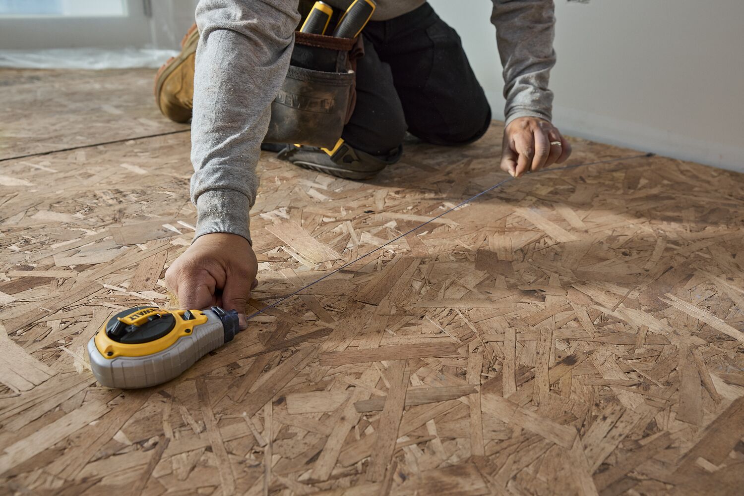 A carpenter uses a chalk reel