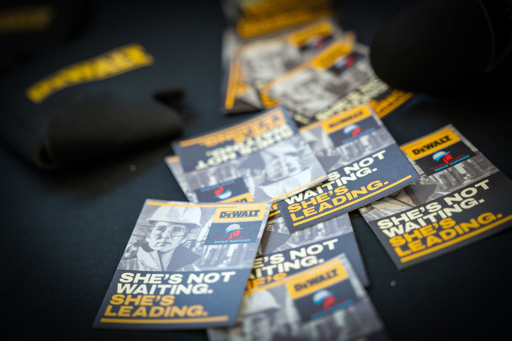 Stickers are scattered on a table at the DEWALT Booth at Tradeswomen Build Nations 2025